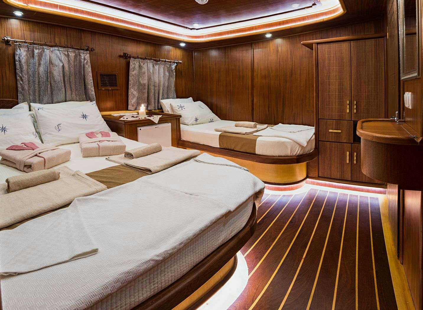a room with beds and a wood cabinet aboard S NUR TAYLAN Yacht for Charter