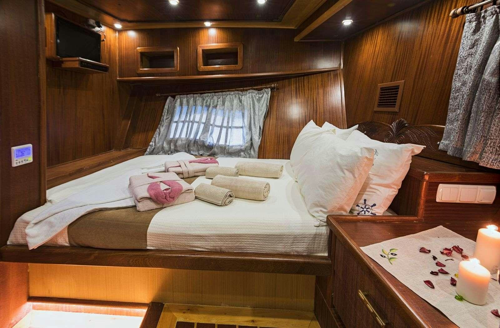 a bed with white sheets and pillows aboard S NUR TAYLAN Yacht for Charter