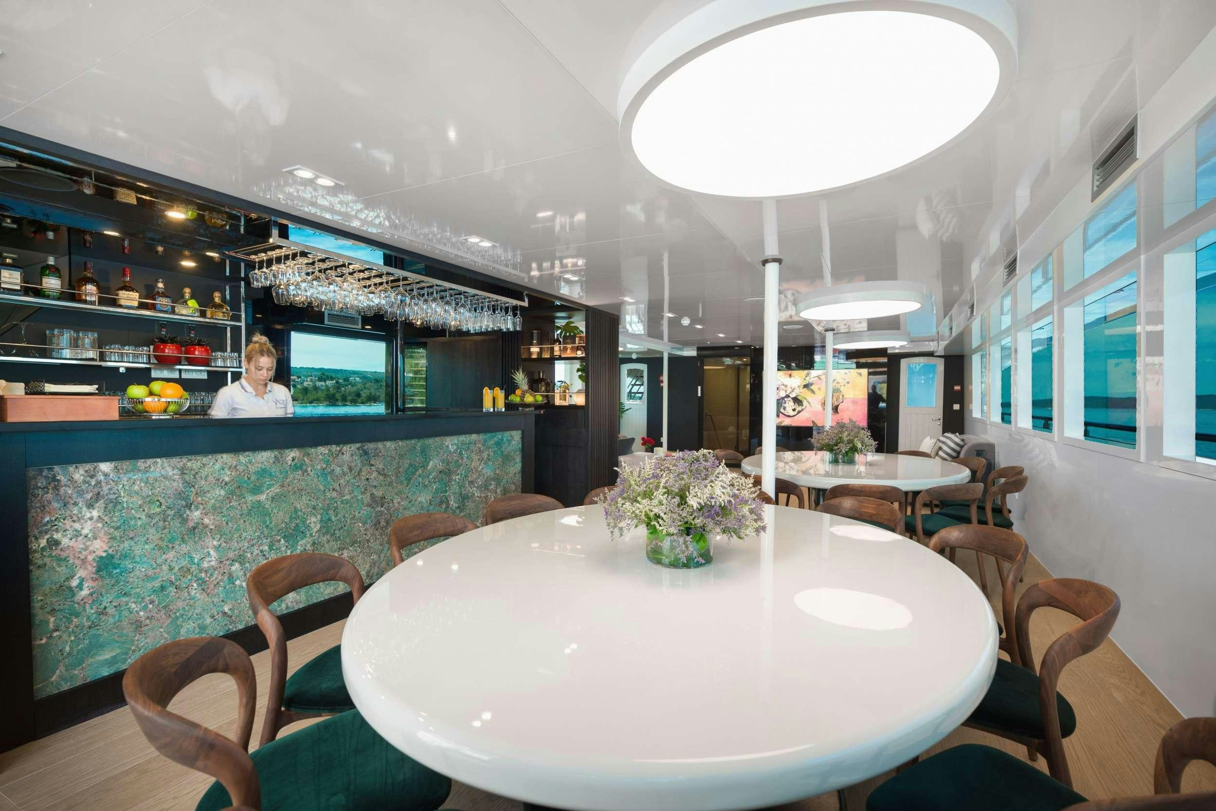 a room with a table and chairs aboard AGAPE ROSE Yacht for Charter