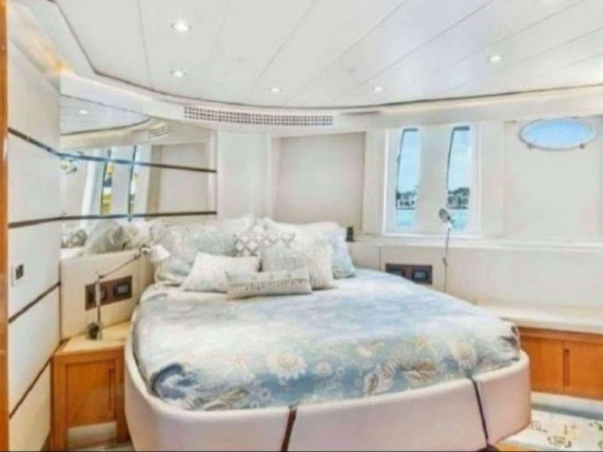 a bedroom with a bed and a window aboard SKY Yacht for Charter