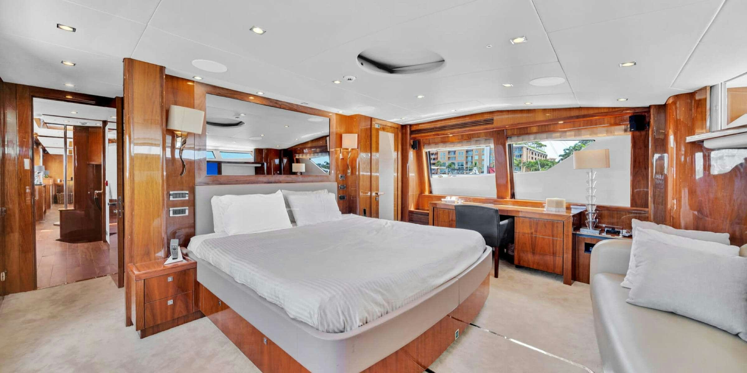 a bedroom with a bed and desk aboard viva la vida Yacht for Charter