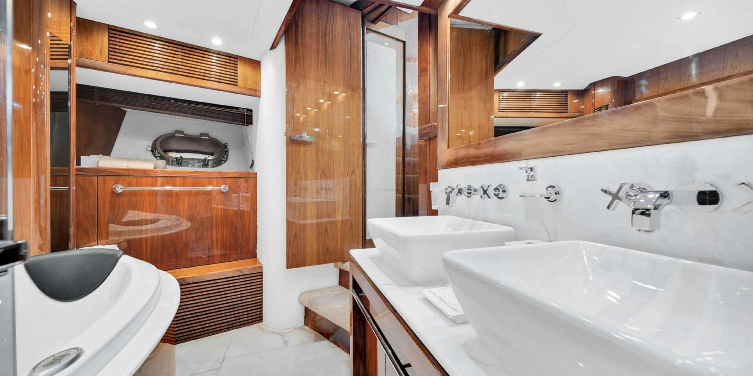 a bathroom with a tub sink and cabinets aboard viva la vida Yacht for Charter