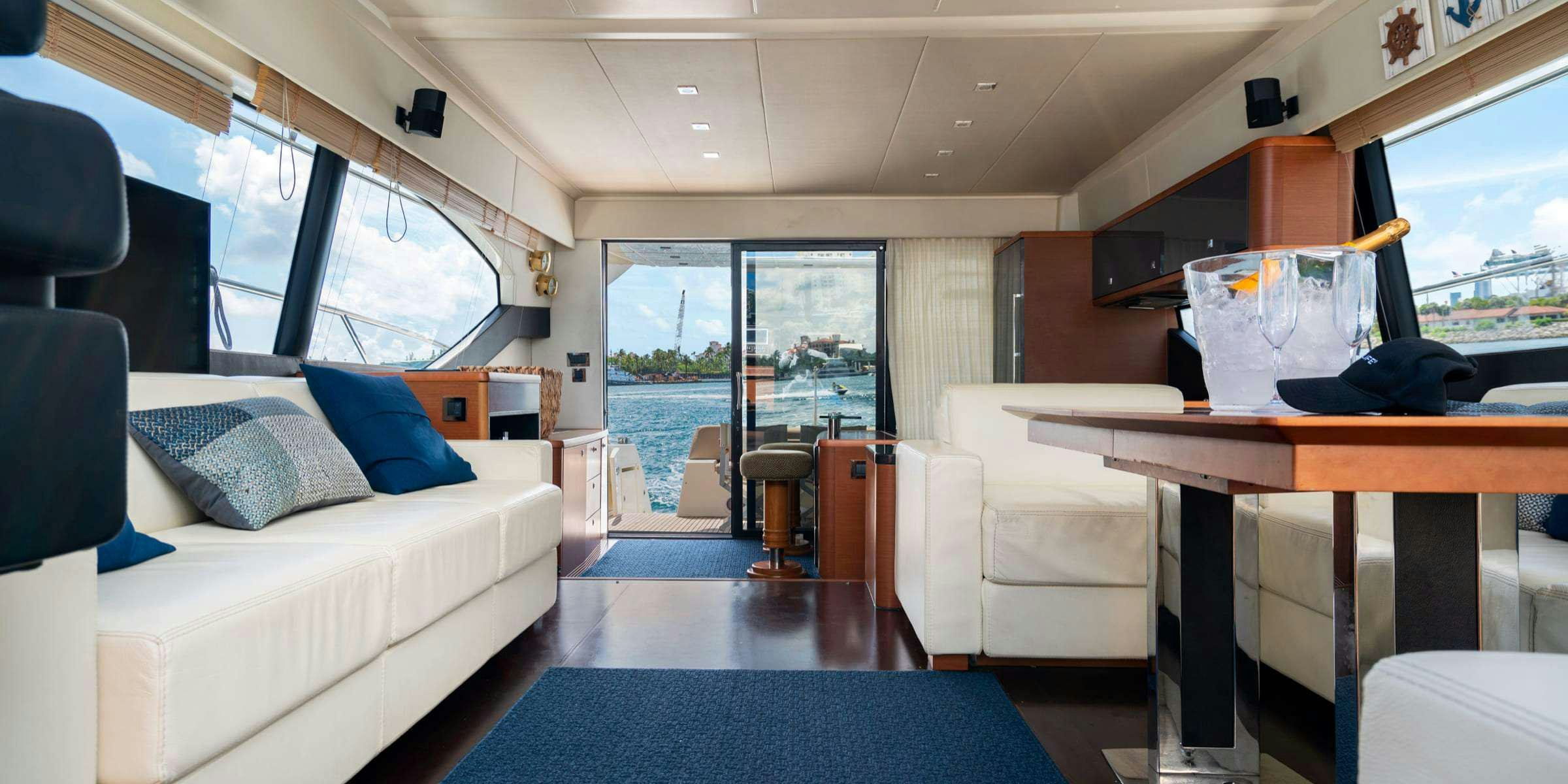 a room with a couch and a table and a window aboard Legacy Yacht for Charter