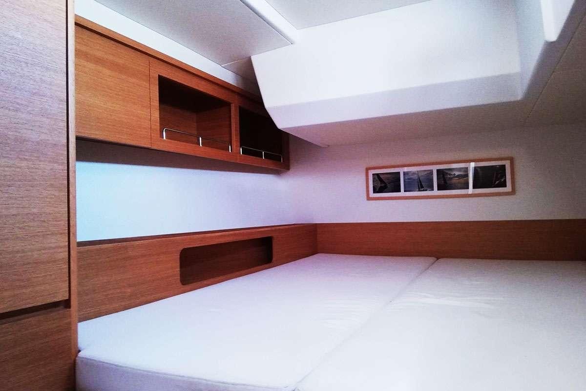 a room with a bed and a television on the wall aboard Futura Yacht for Charter