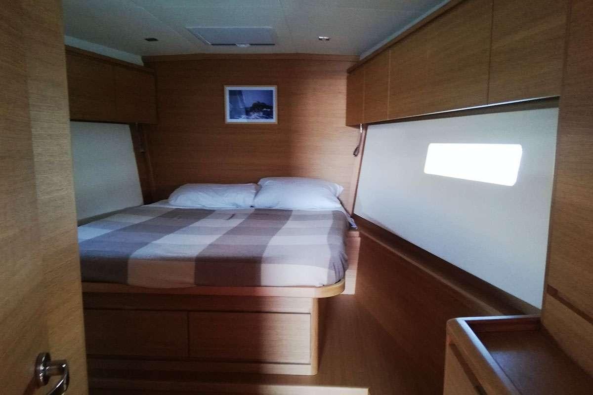 a room with a bed and a wood cabinet aboard Futura Yacht for Charter