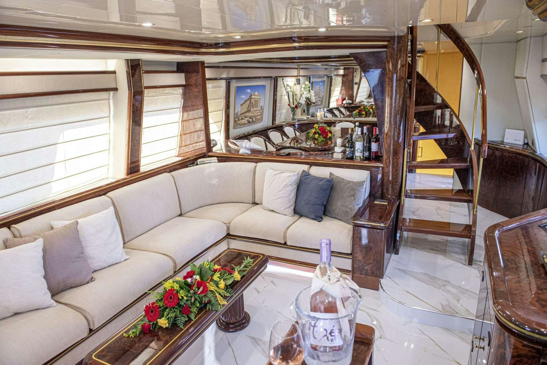 a living room with a white couch and a wood staircase aboard WISH Yacht for Charter