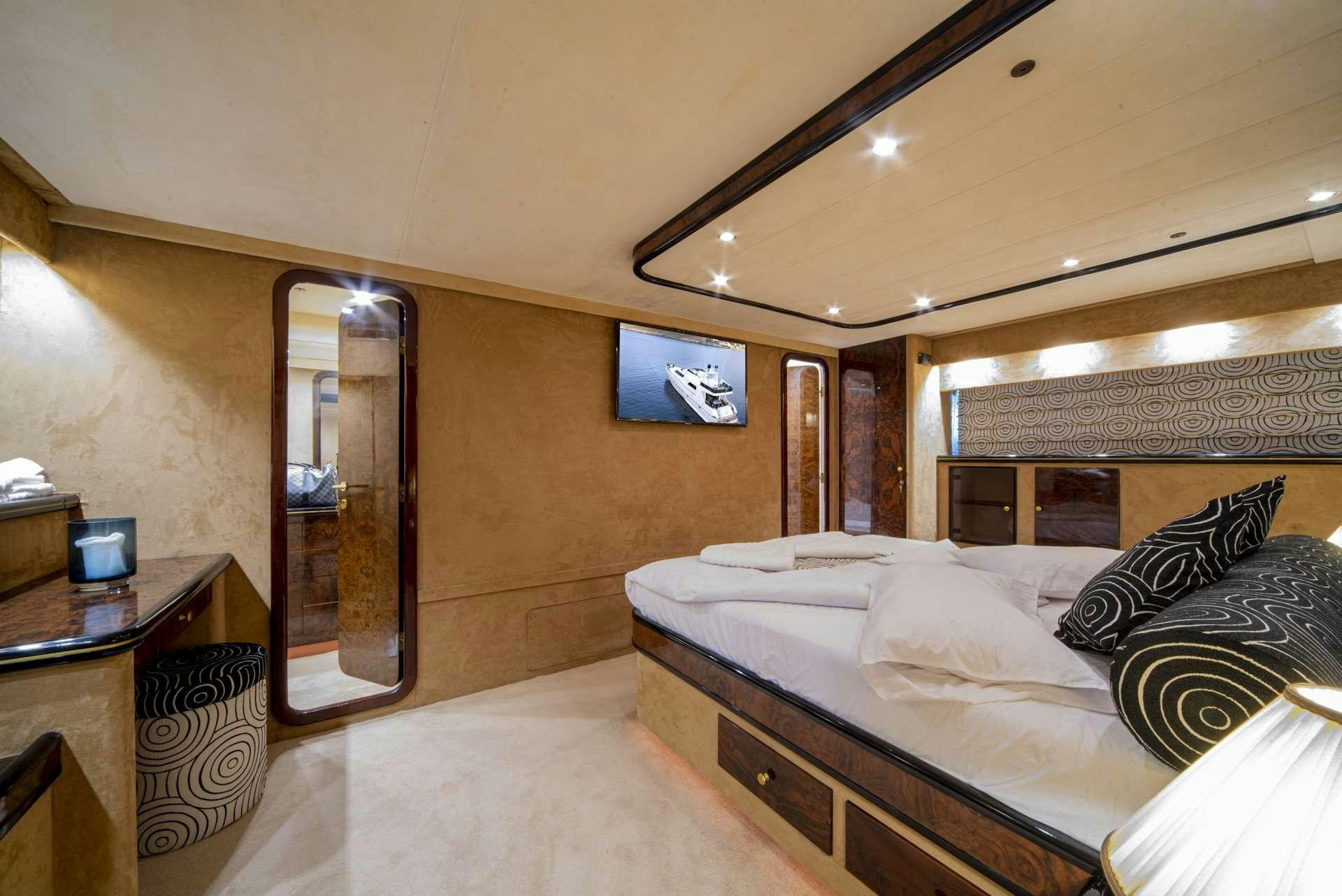 a bedroom with a bed and a mirror aboard WISH Yacht for Charter