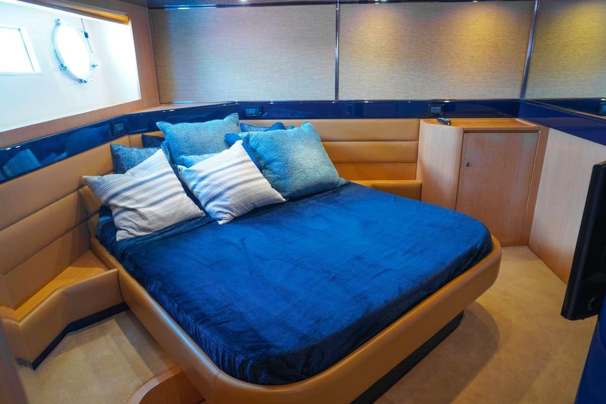 a bed with blue sheets aboard EXPRESSO Yacht for Charter