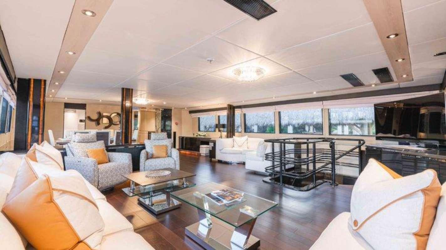 a living room with a large glass coffee table aboard QUANTUM Yacht for Charter