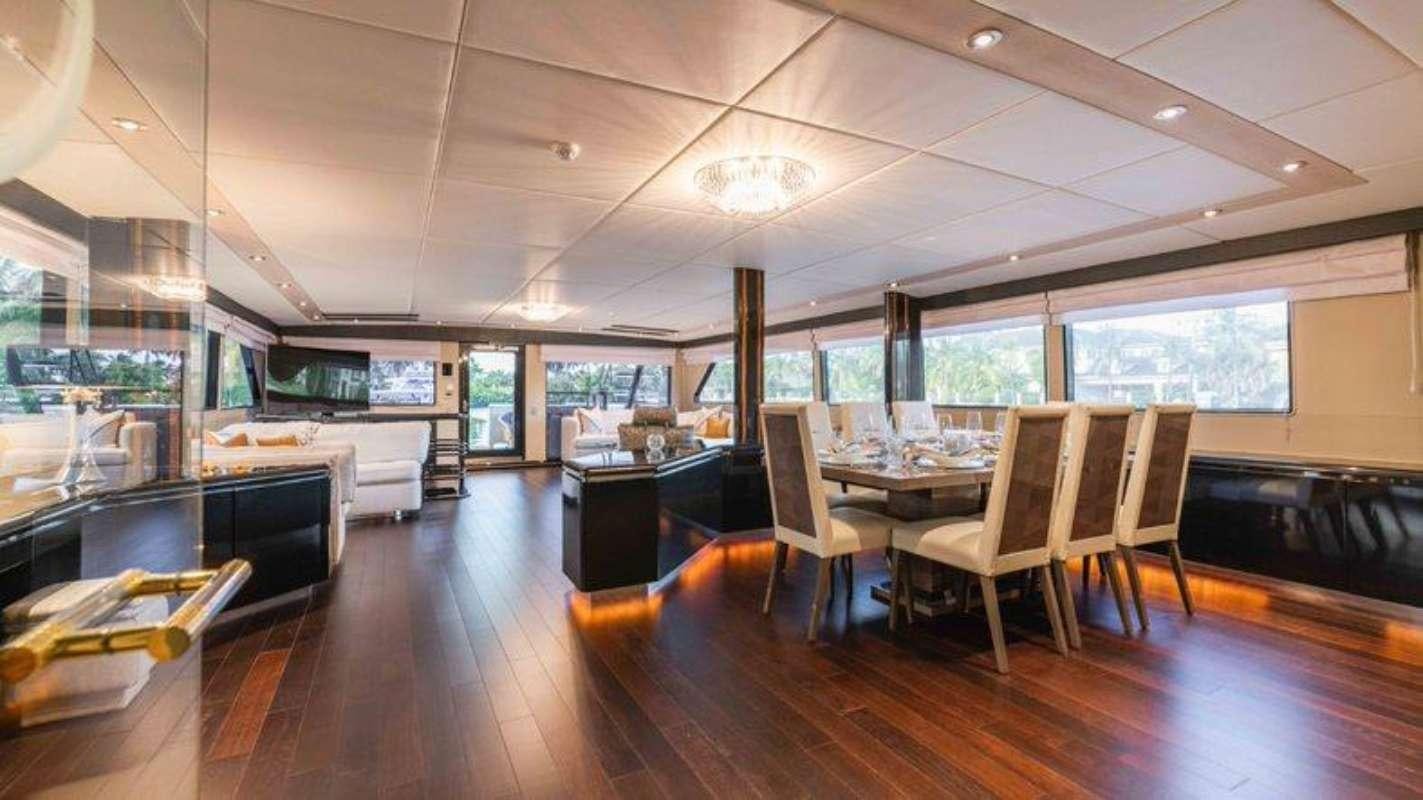 a room with a table chairs and a tv aboard QUANTUM Yacht for Charter
