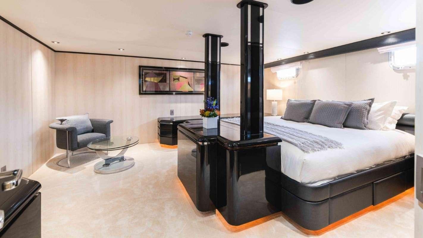 a room with a bed and a desk aboard QUANTUM Yacht for Charter
