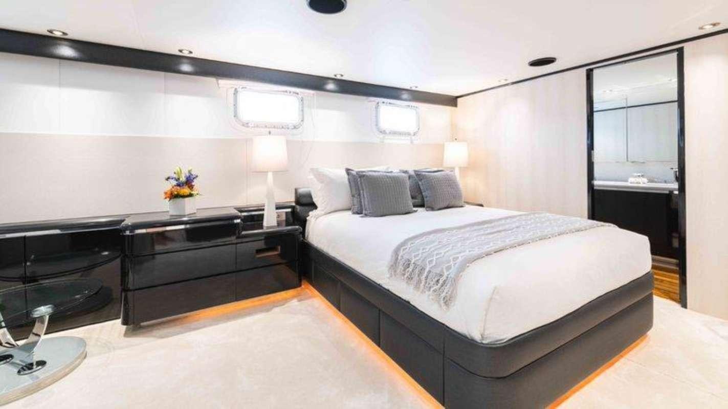 a bedroom with a bed and a desk aboard QUANTUM Yacht for Charter