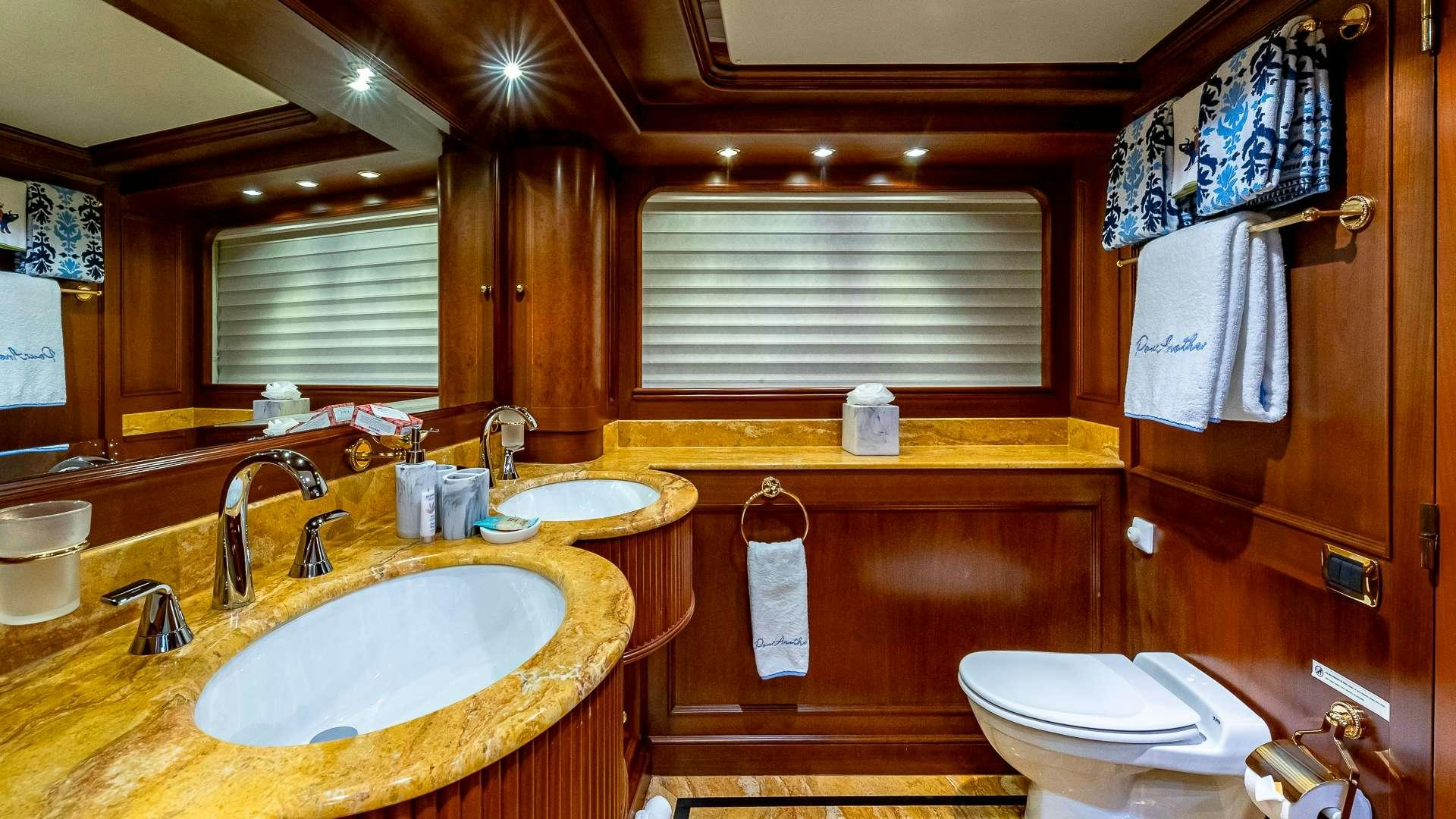a bathroom with a sink toilet and towels aboard POUR ANOTHER Yacht for Charter