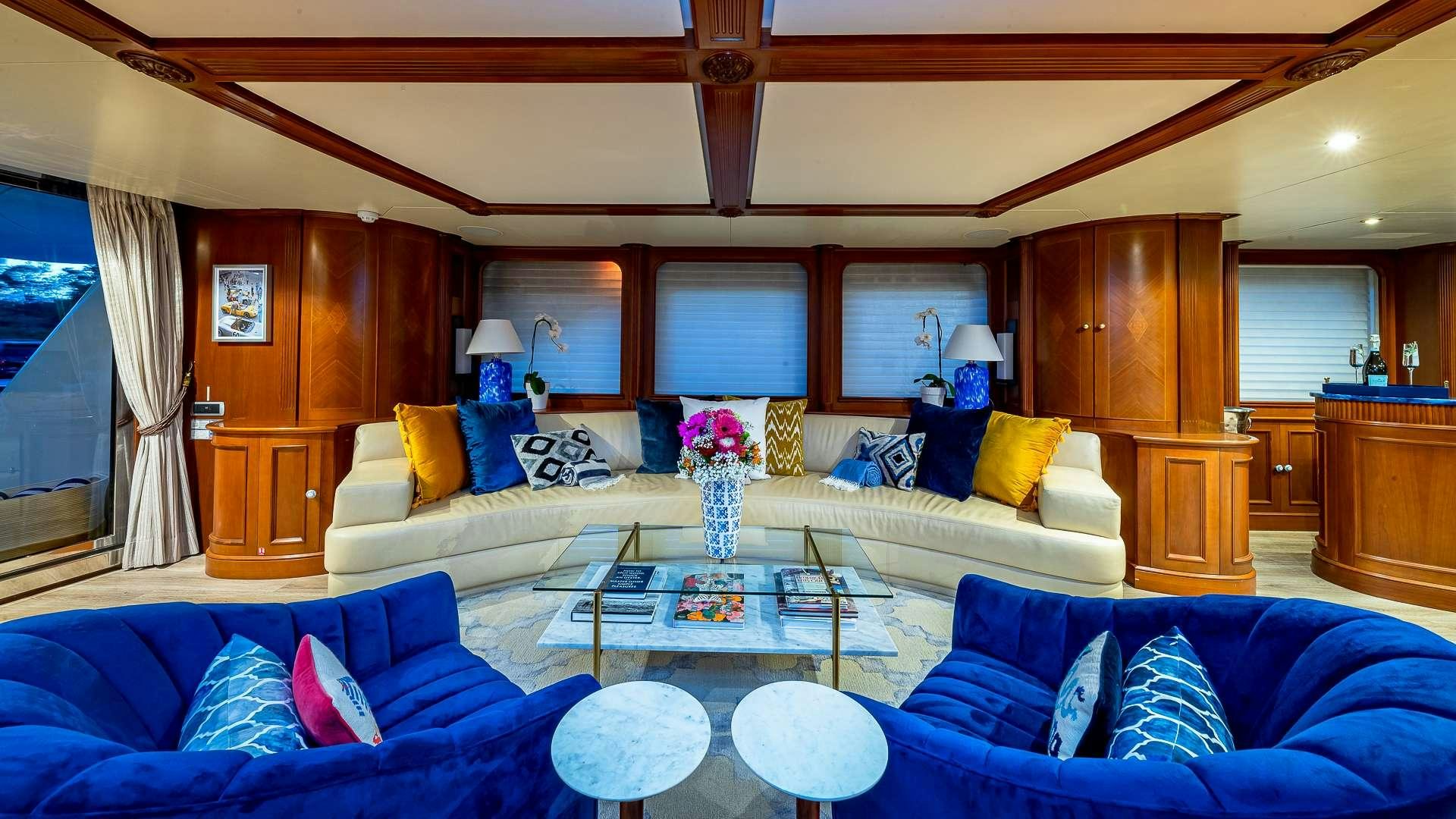 a living room with a blue couch and a coffee table aboard POUR ANOTHER Yacht for Charter