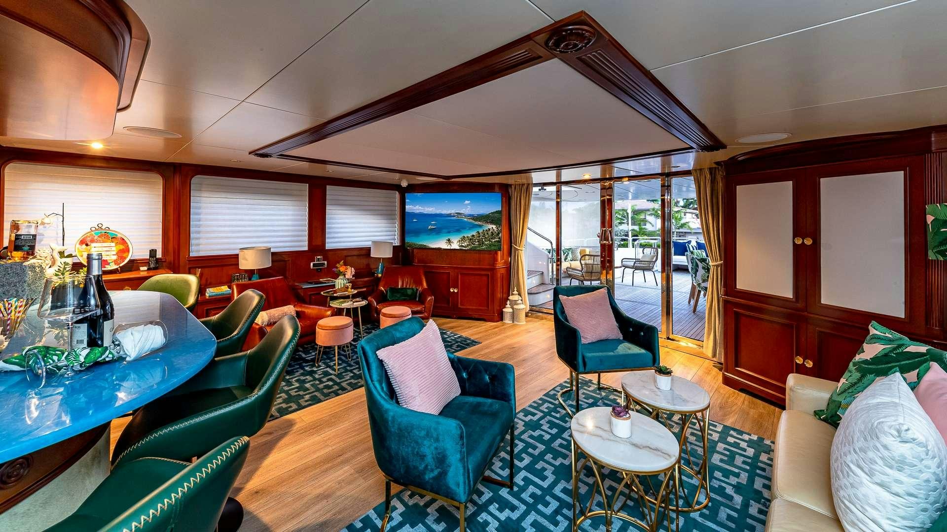 a room with a table chairs and a television aboard POUR ANOTHER Yacht for Charter
