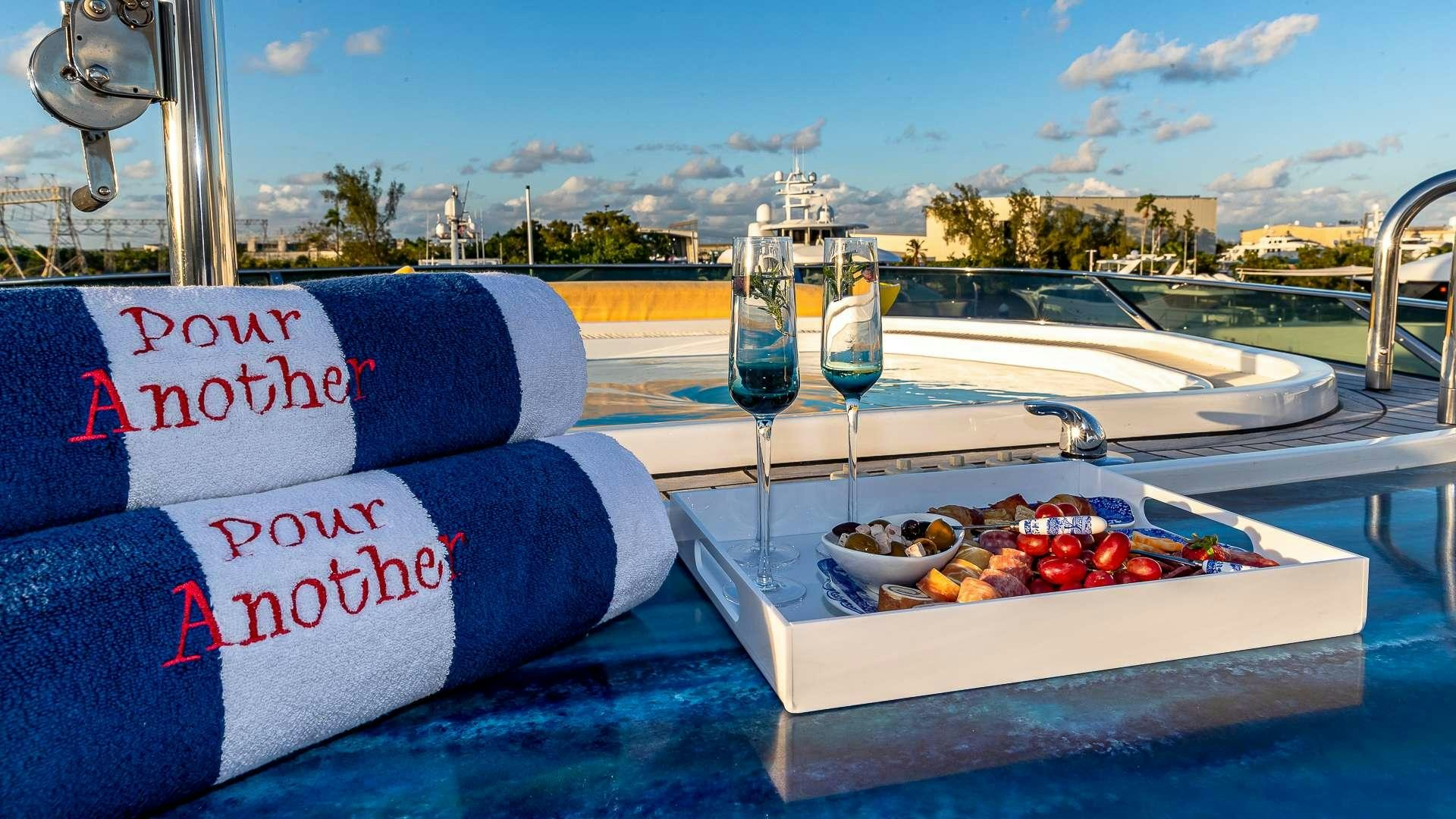 a table with a glass of wine and a bottle of wine on it aboard POUR ANOTHER Yacht for Charter