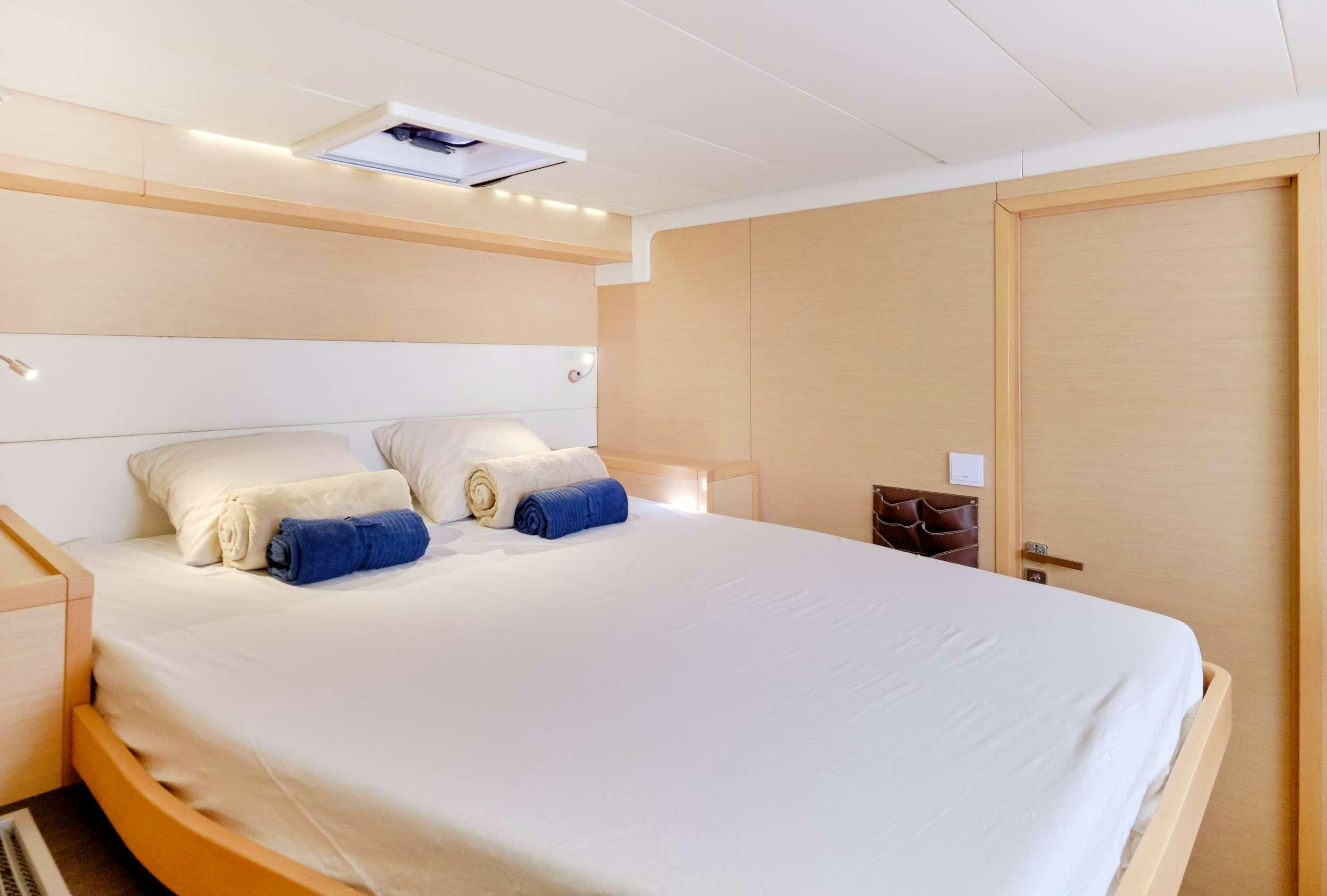 a bed with white sheets aboard Neptuno Yacht for Charter