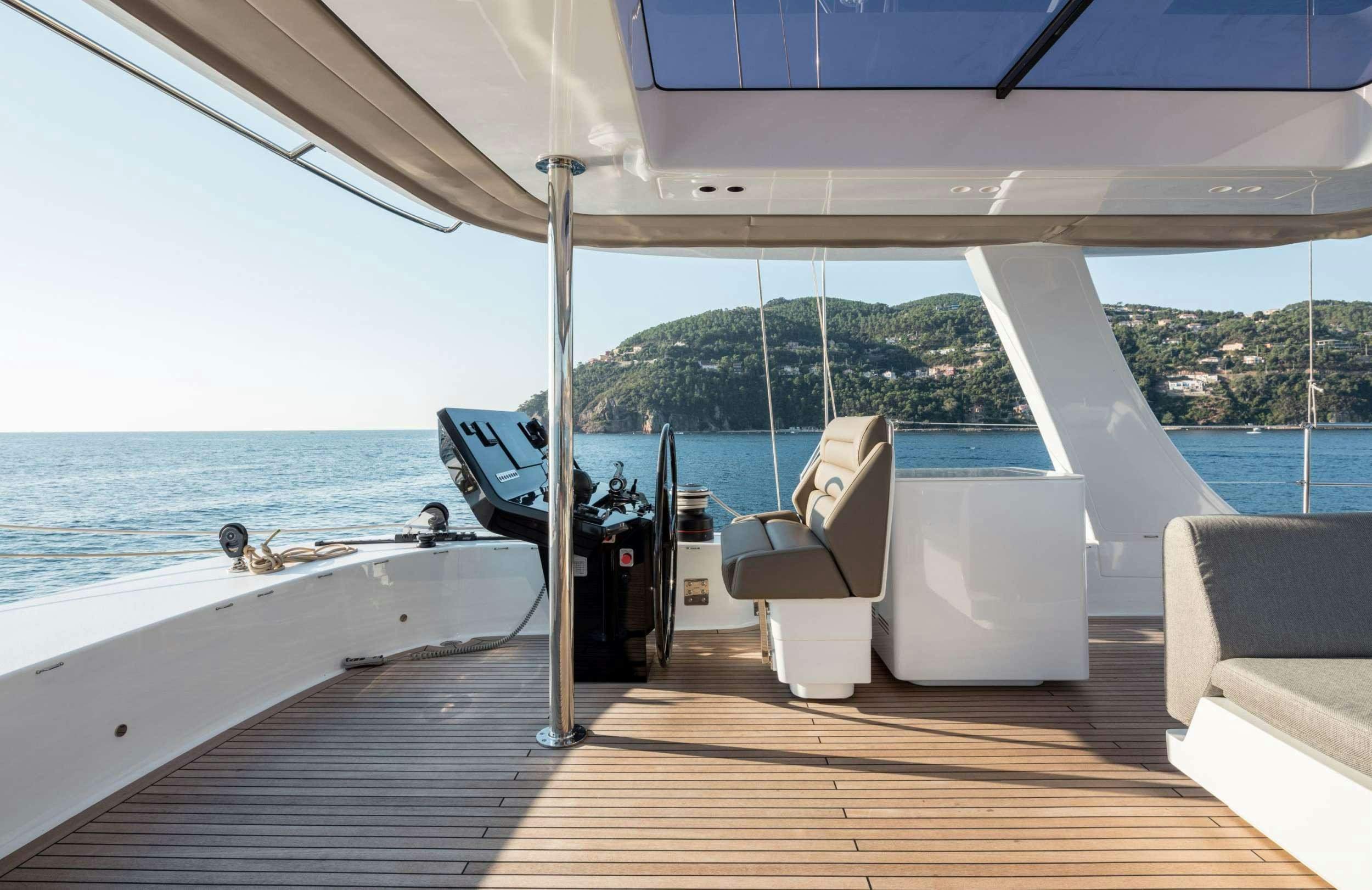 a deck with a large body of water and a boat on it aboard ANIMA Yacht for Charter