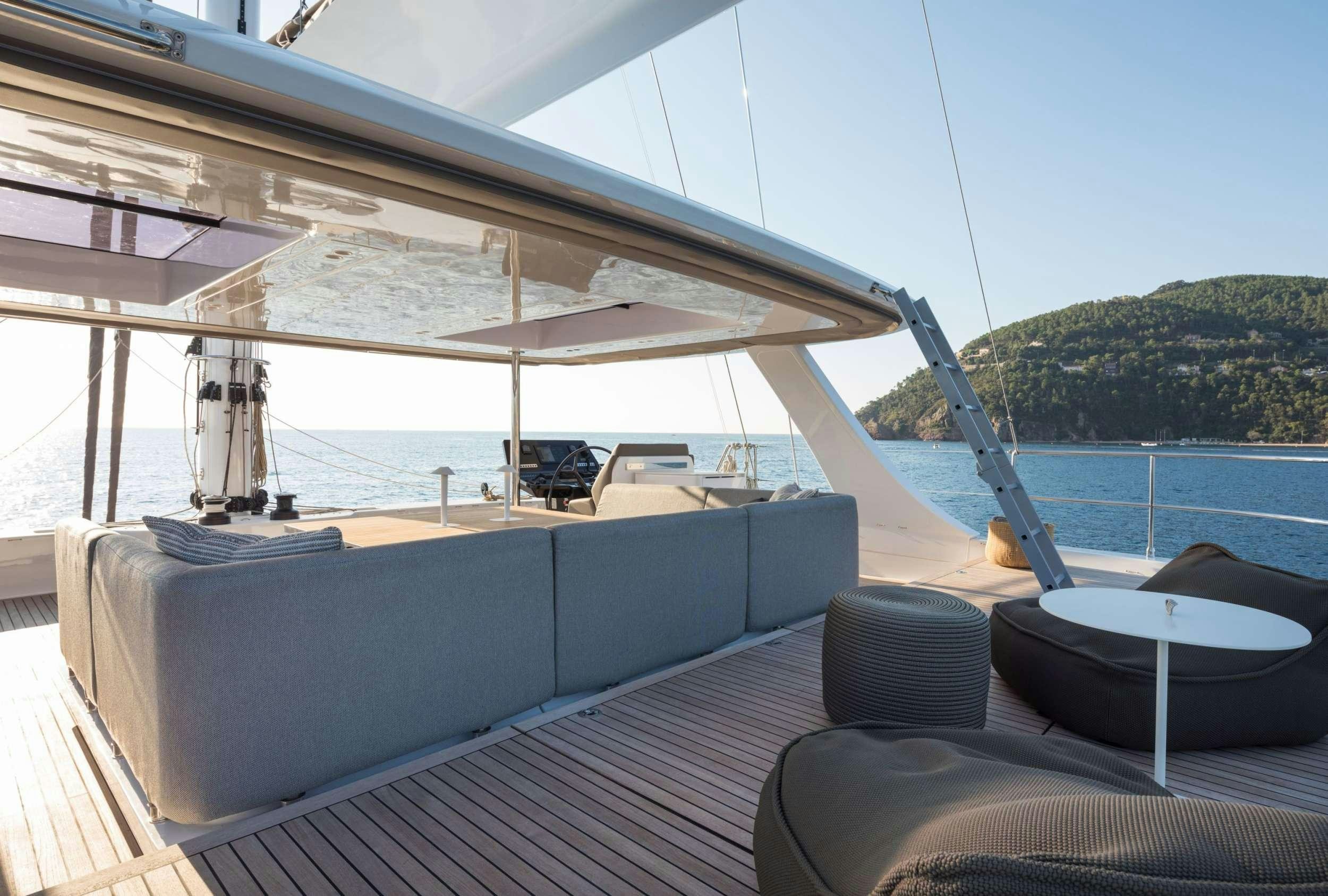 a deck with a large body of water and a large boat on it aboard ANIMA Yacht for Charter