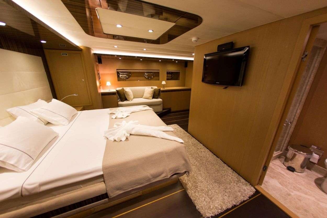 a room with a bed and a television aboard LE PIETRE Yacht for Charter