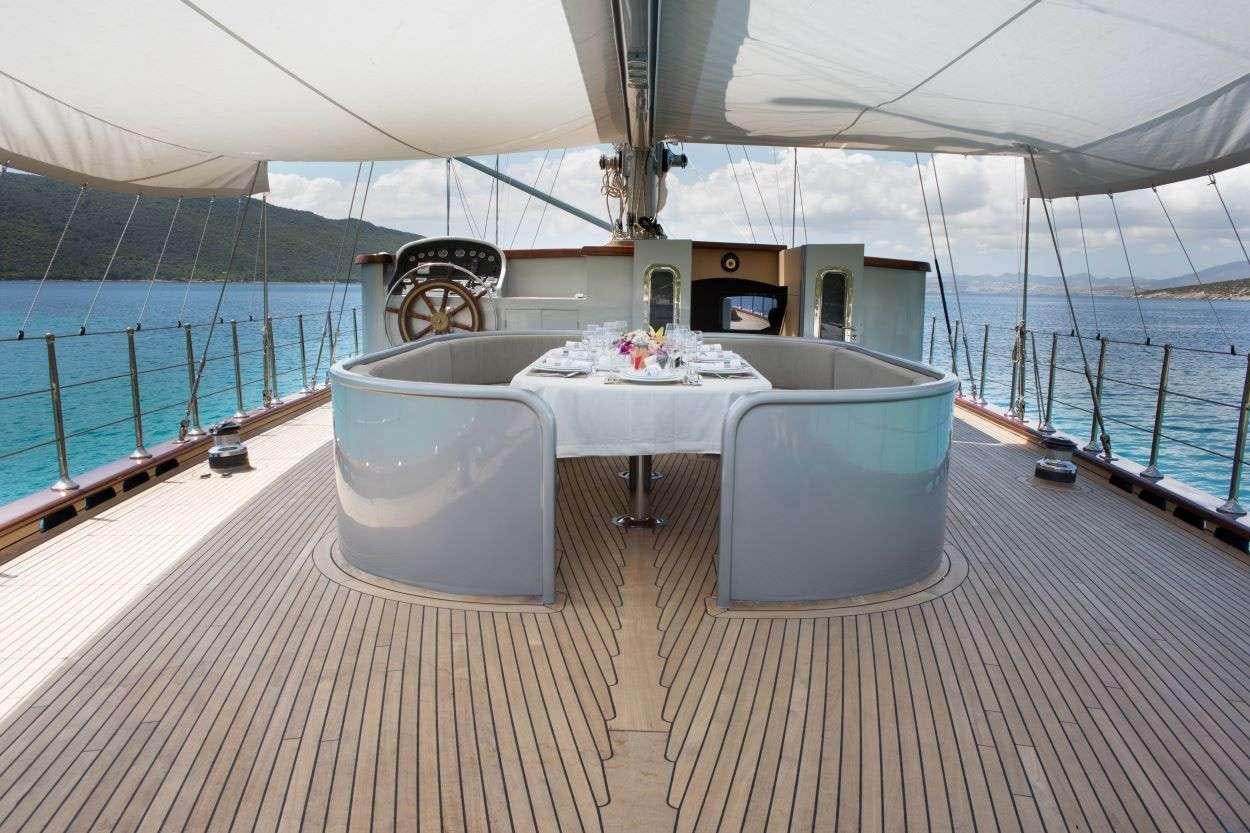 a table and chairs on a deck aboard LE PIETRE Yacht for Charter