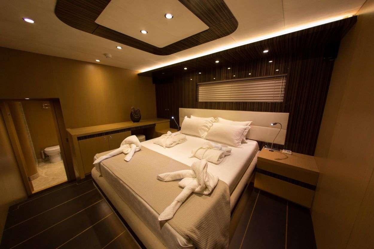 a room with a bed and a mirror aboard LE PIETRE Yacht for Charter