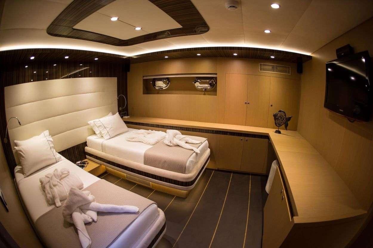 a room with beds and a tv aboard LE PIETRE Yacht for Charter