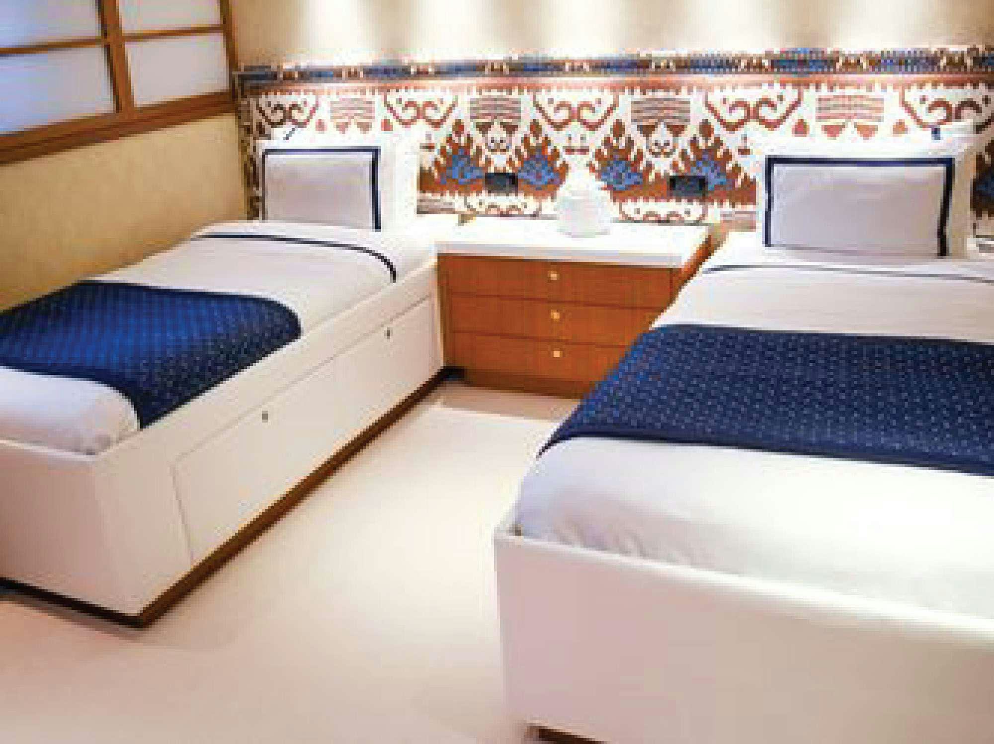 a room with a bed and a dresser aboard OCTOPUSSY Yacht for Charter
