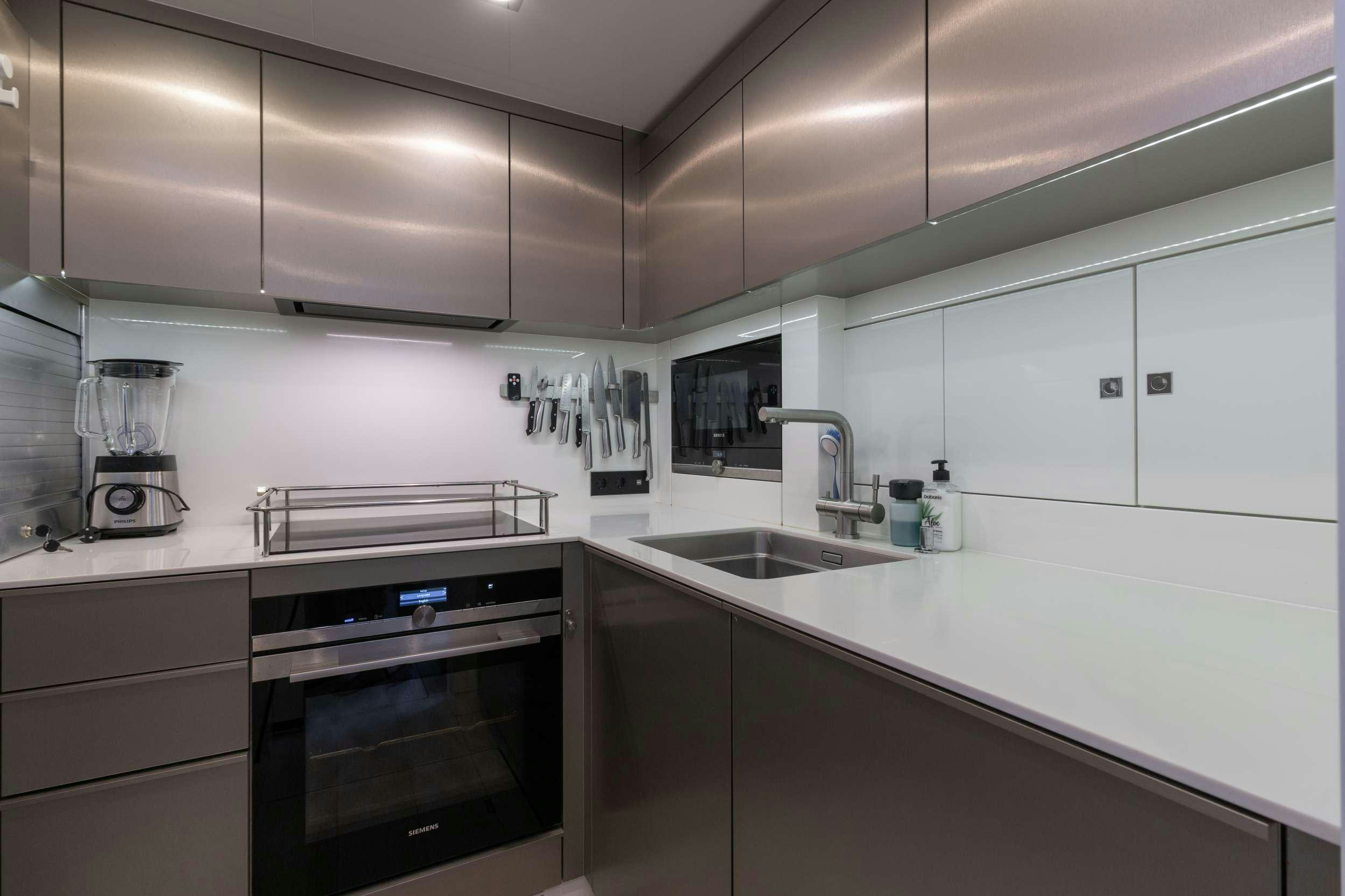 a kitchen with white cabinets aboard OCEAN VIBES Yacht for Charter