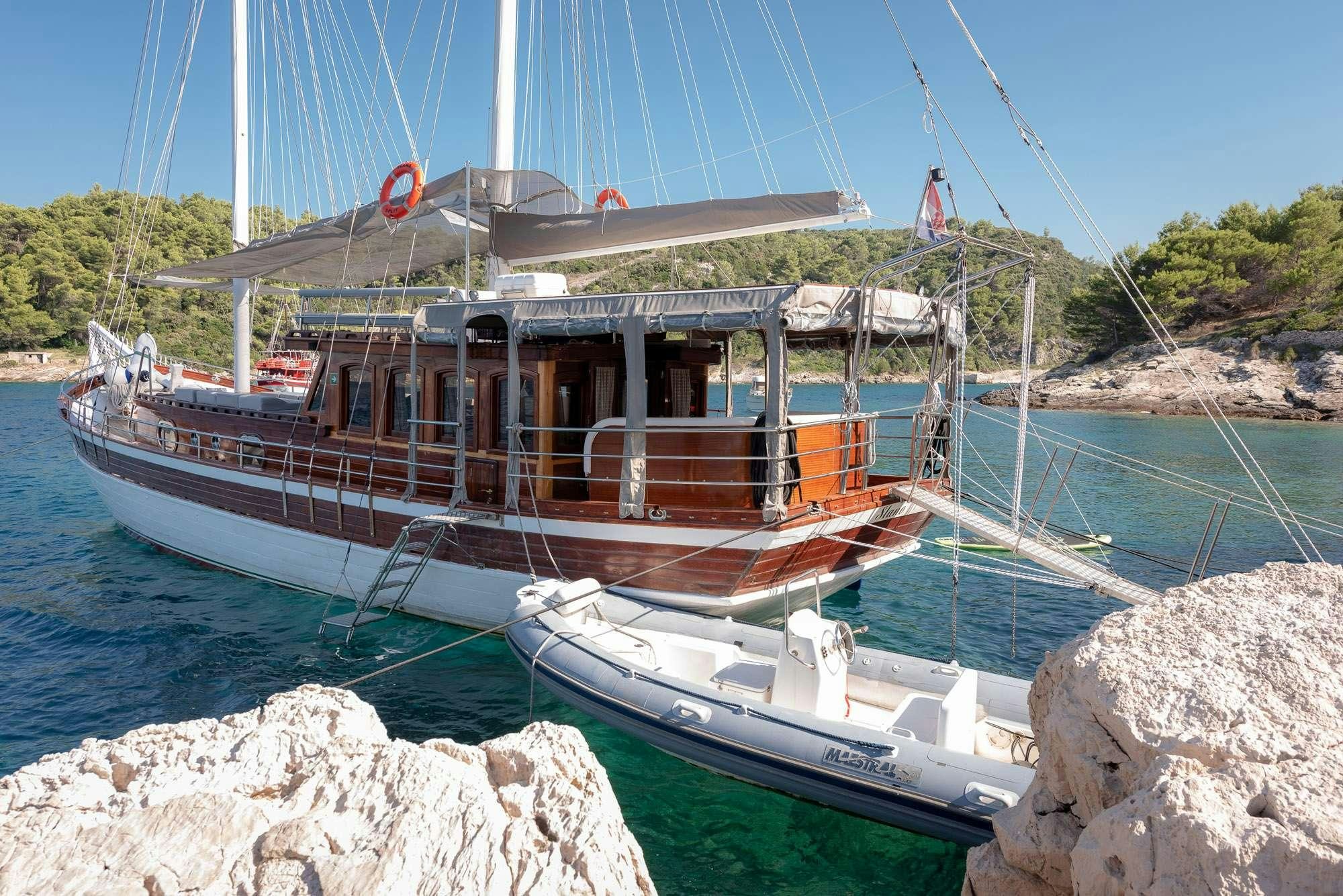 a boat tied to a rock aboard SLANO Yacht for Charter