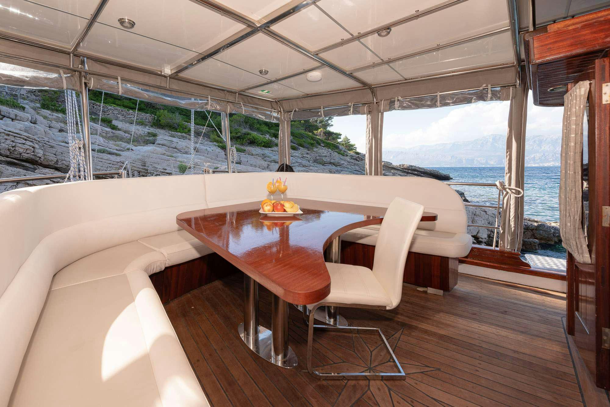 a room with a table and chairs aboard SLANO Yacht for Charter