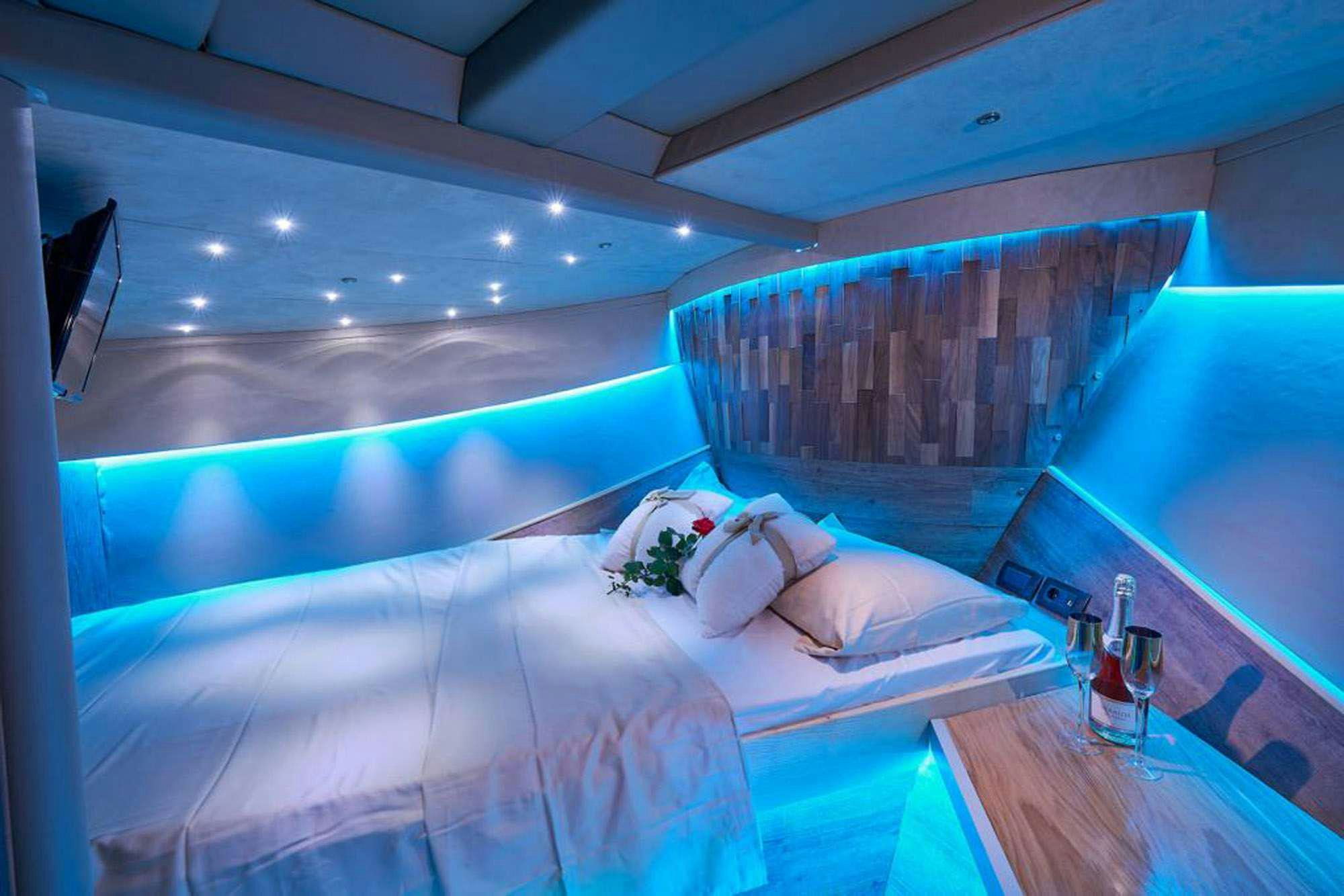 a room with a bed and a table aboard SLANO Yacht for Charter