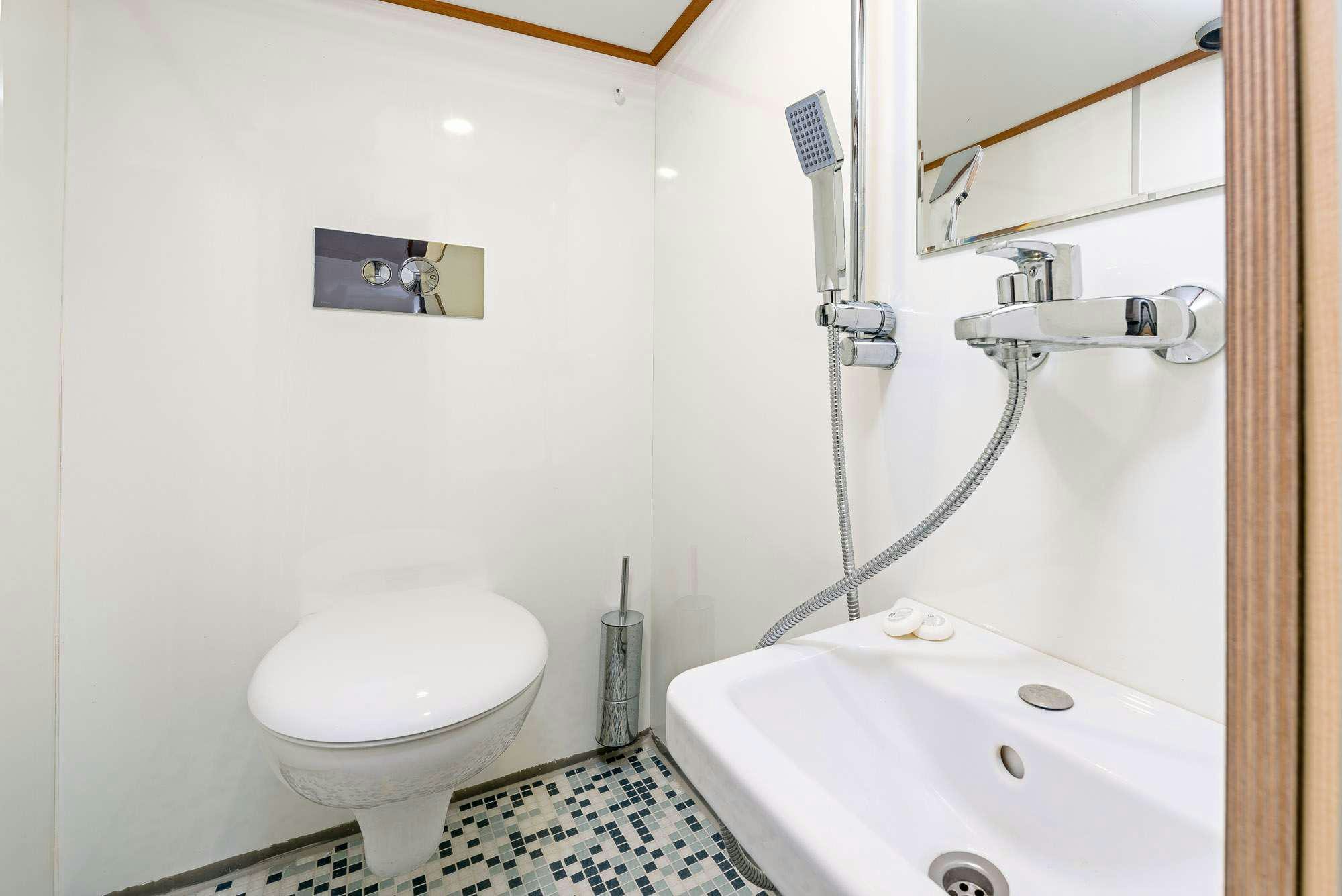 a bathroom with a toilet and bathtub aboard SLANO Yacht for Charter