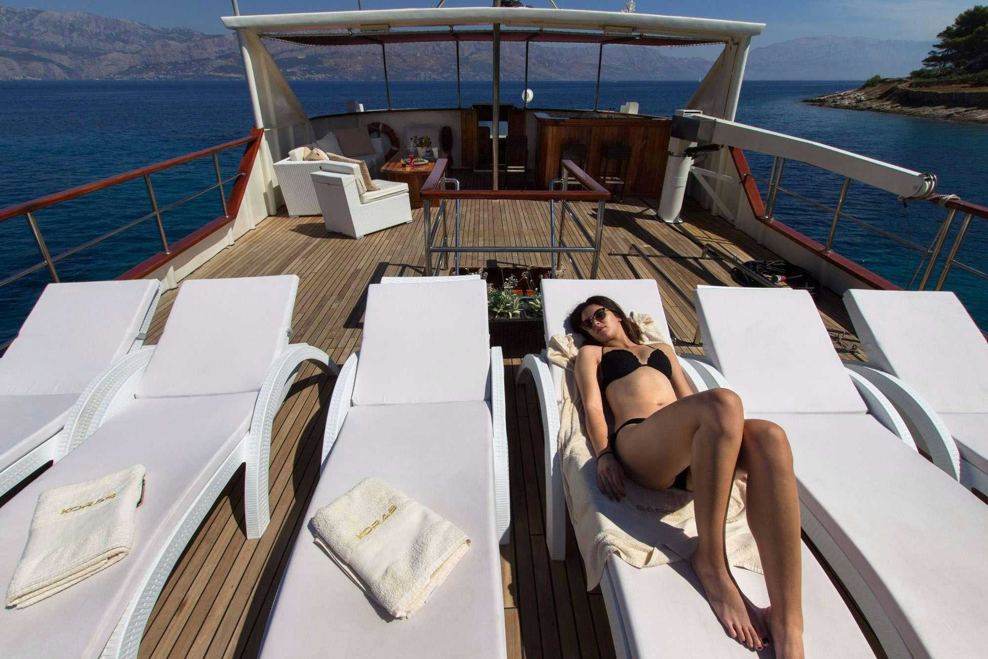 a person lying on a lounge chair on a boat aboard KORAB Yacht for Charter