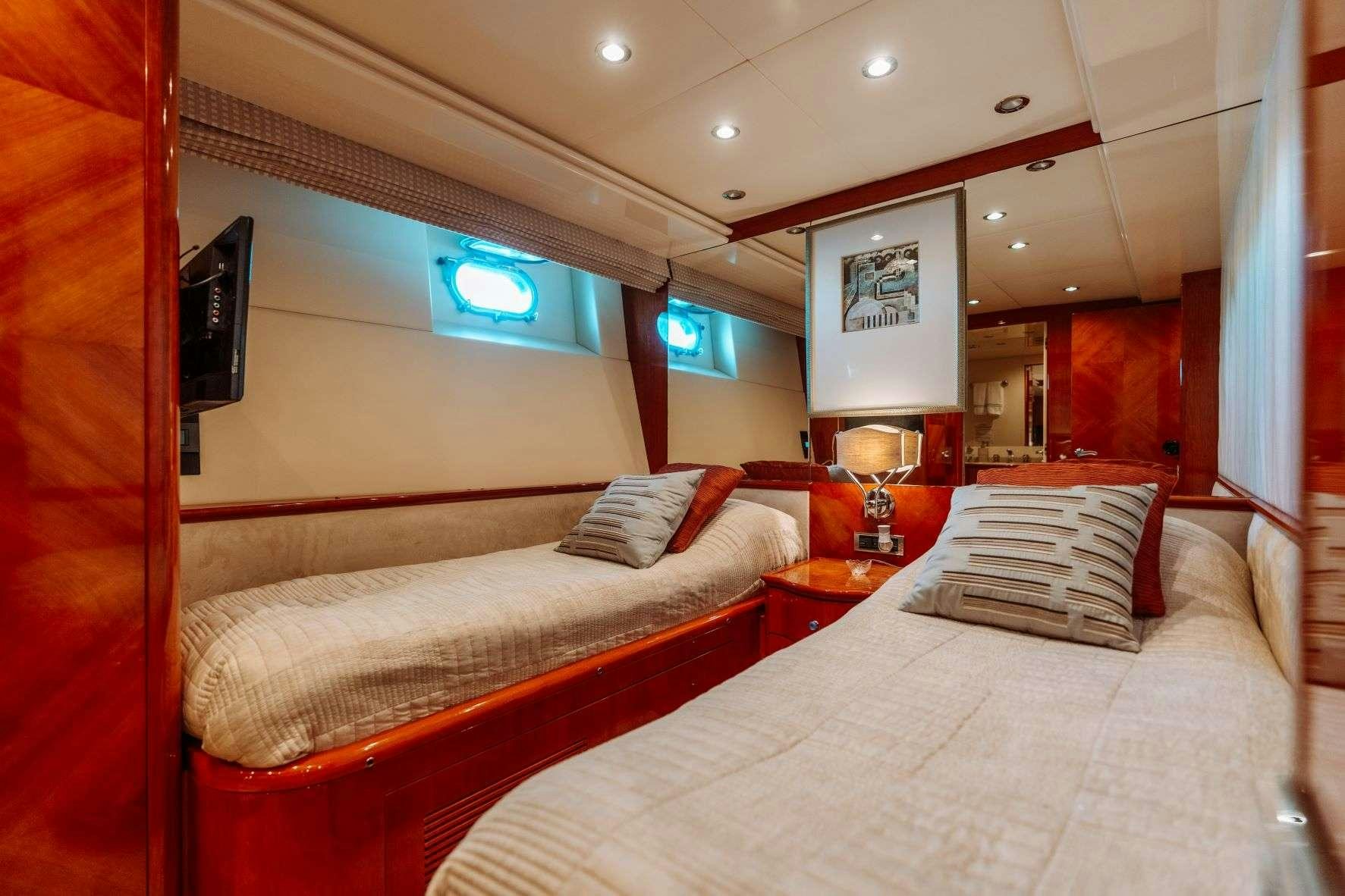 a room with a bed and a television aboard ENDLESS SUN Yacht for Charter