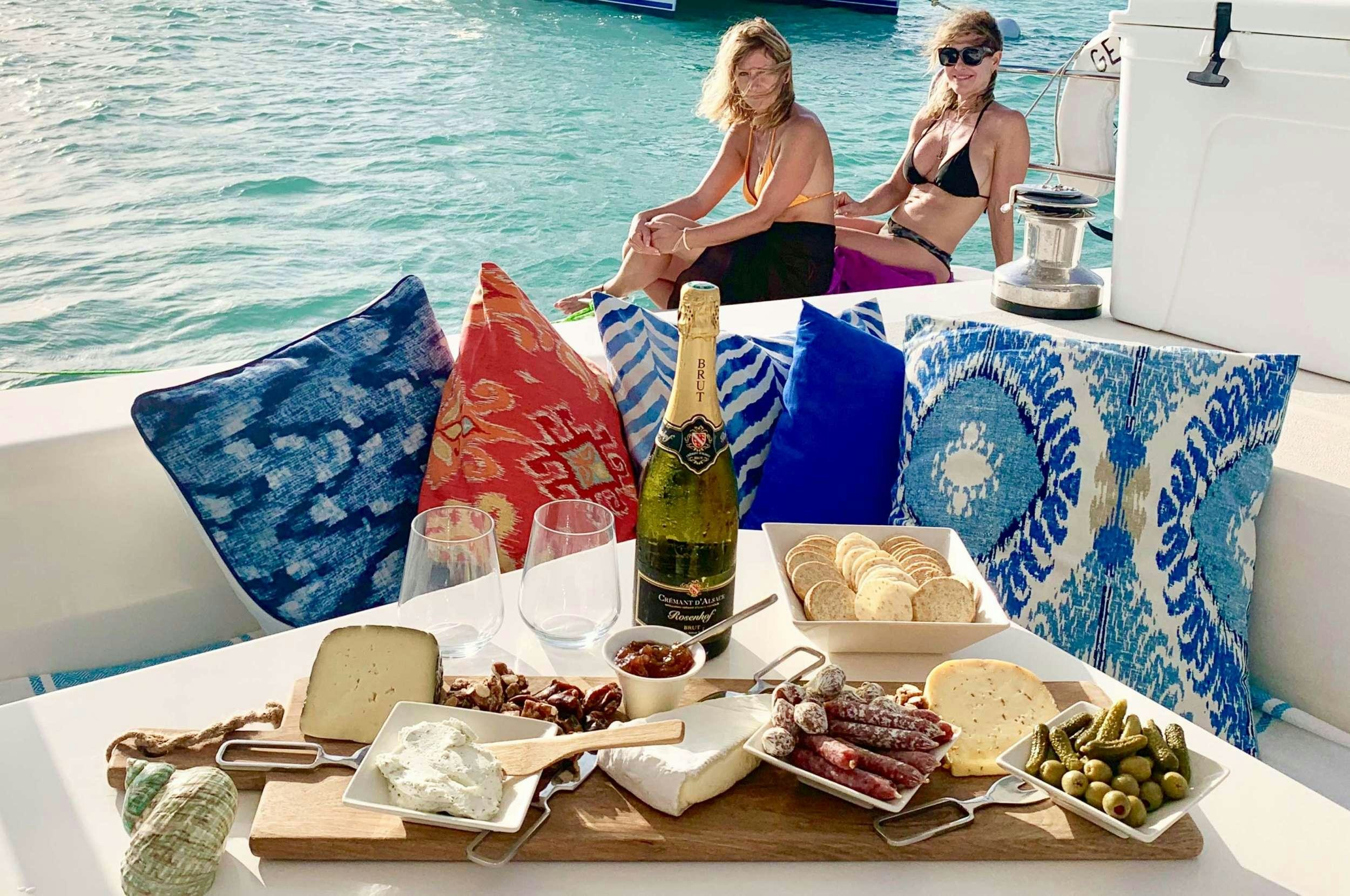 a table with food and drinks on it by the water aboard Genesis II Yacht for Charter