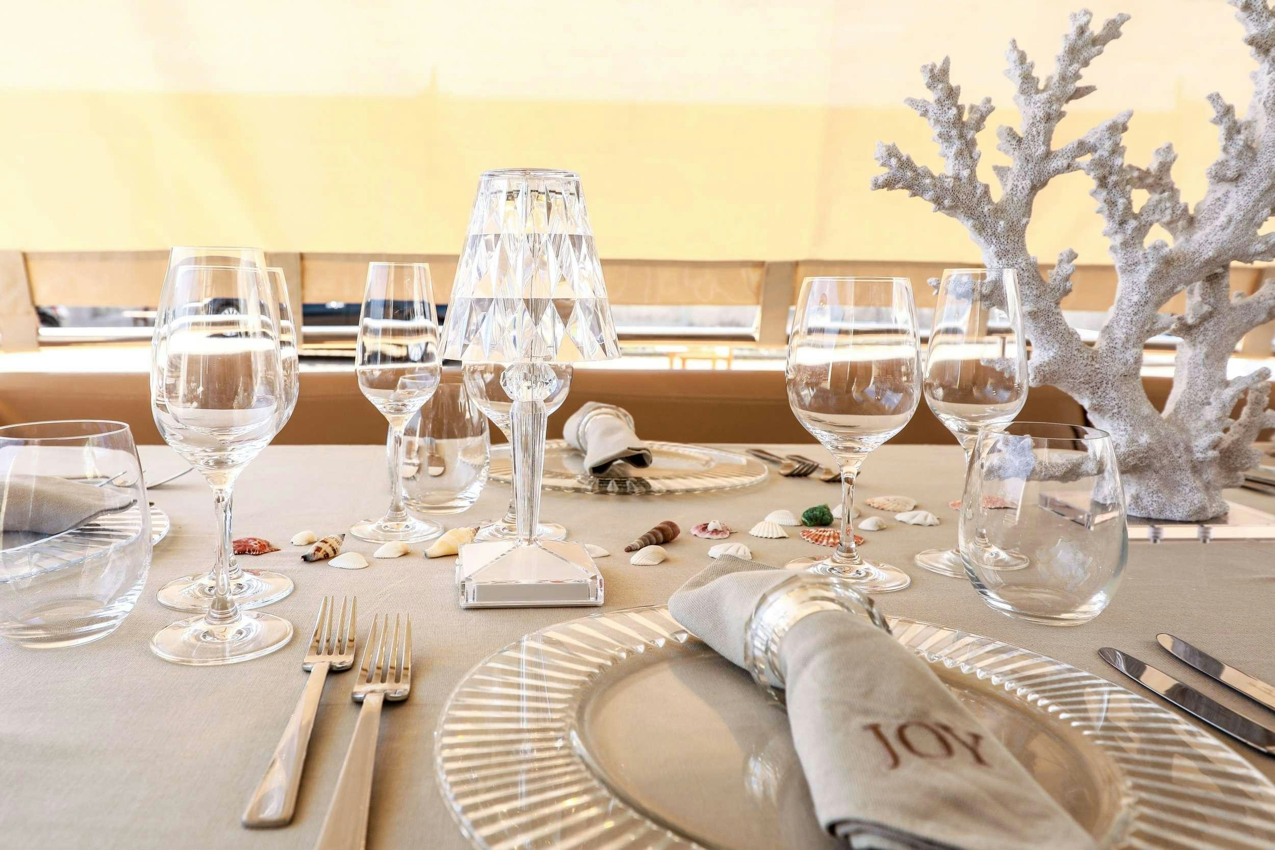 a table with wine glasses and napkins on it aboard JOY Yacht for Charter