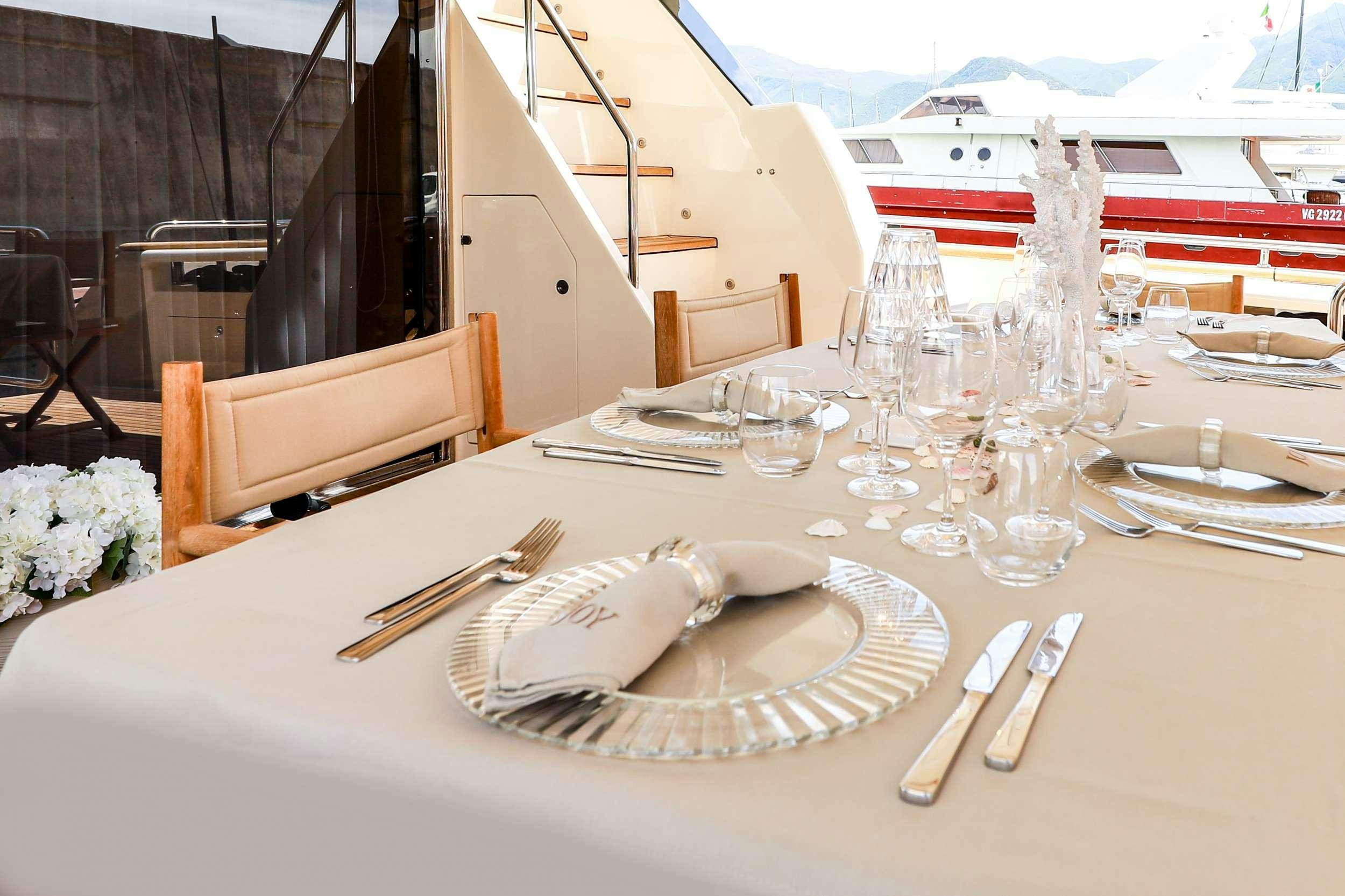 a table with plates and silverware aboard JOY Yacht for Charter