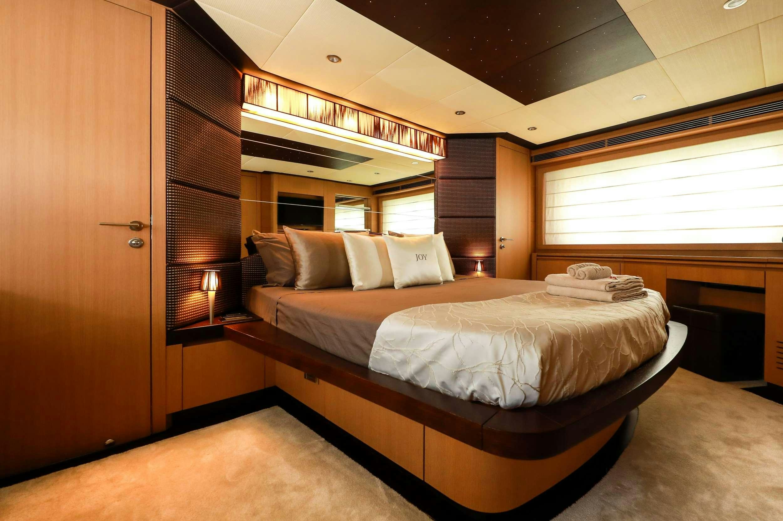 a room with a bed and a wood door aboard JOY Yacht for Charter
