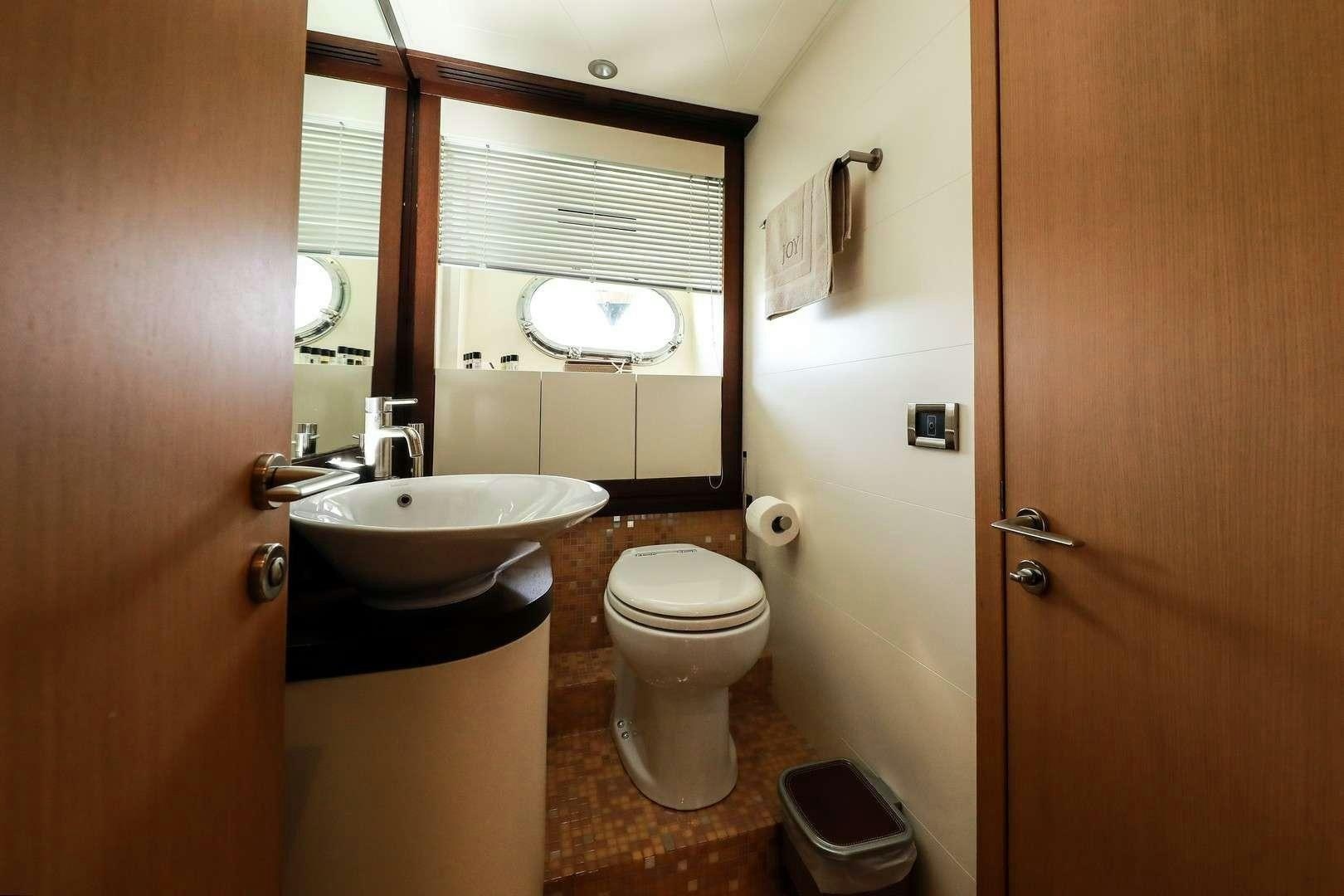 a bathroom with a sink toilet and a mirror aboard JOY Yacht for Charter