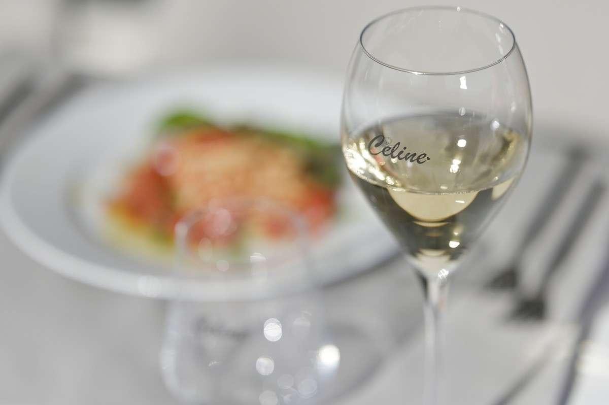 a glass of wine next to a plate of food aboard Celine Yacht for Charter