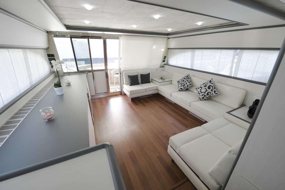 a large living room with white couches and a table aboard Celine Yacht for Charter
