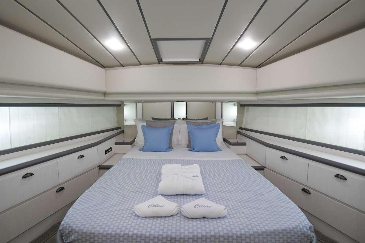 a large white bed with blue pillows aboard Celine Yacht for Charter
