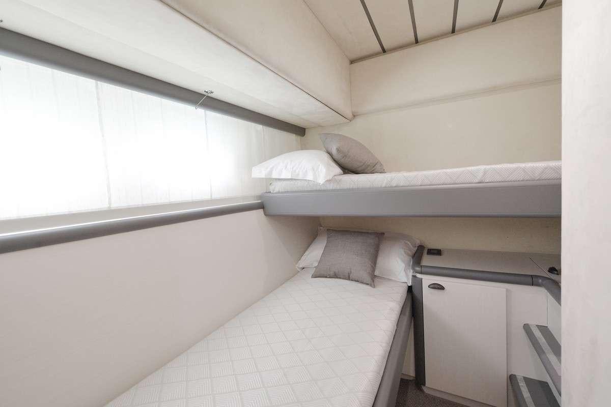 a bed with white sheets aboard Celine Yacht for Charter