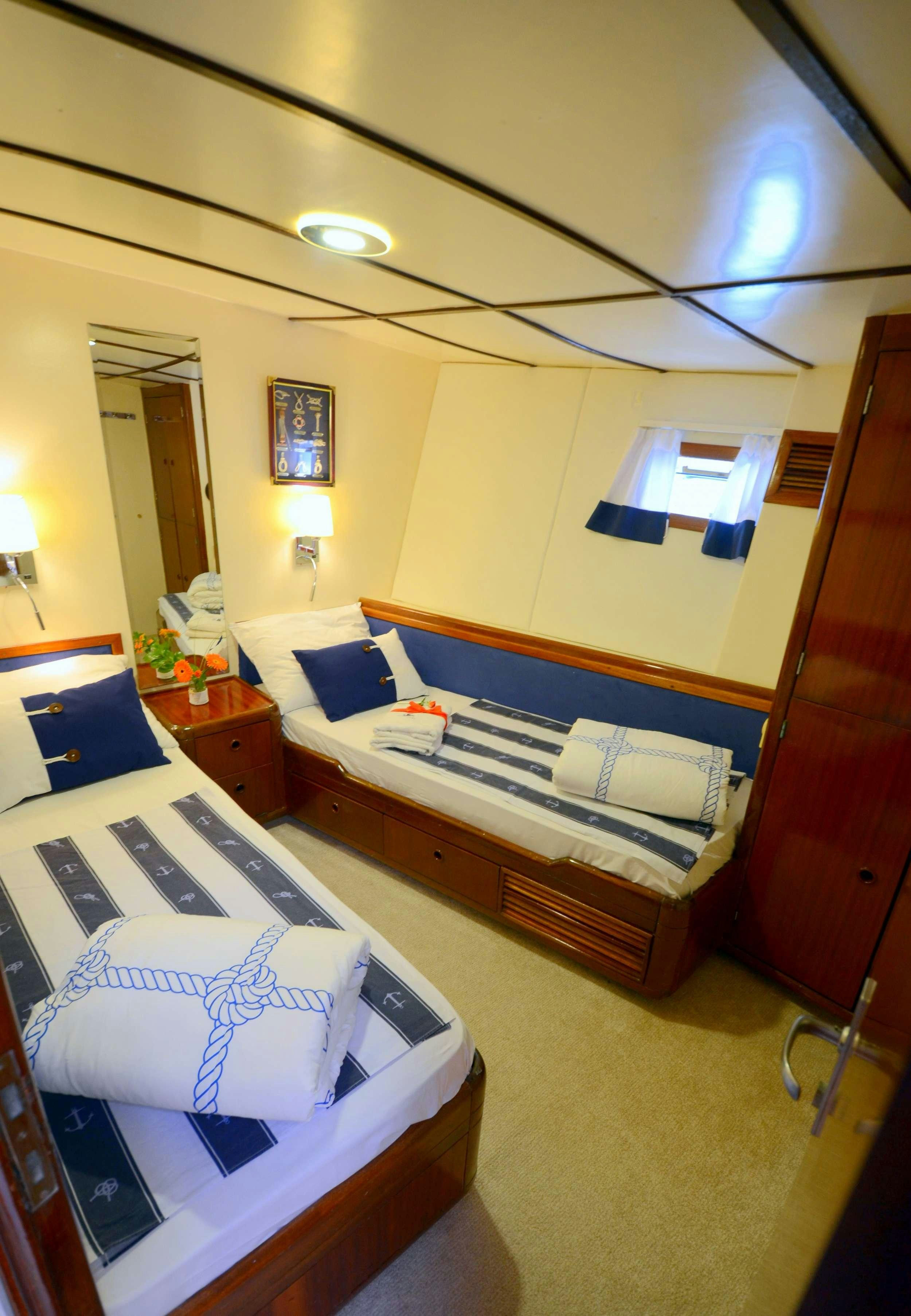 a bedroom with a bed and desk aboard FORTUNA Yacht for Charter