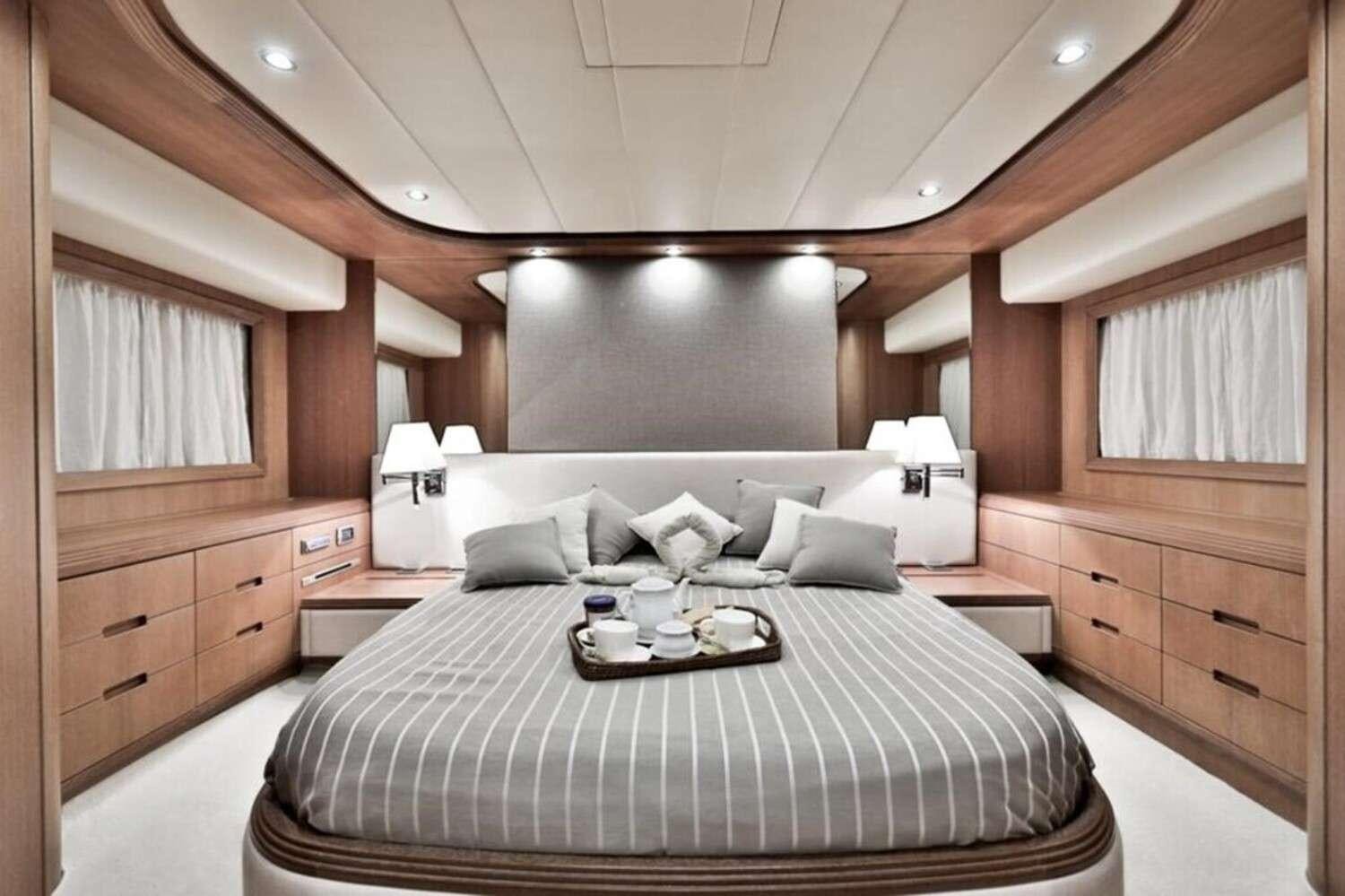 a bed with a white bed spread aboard RESILIENCE Yacht for Charter