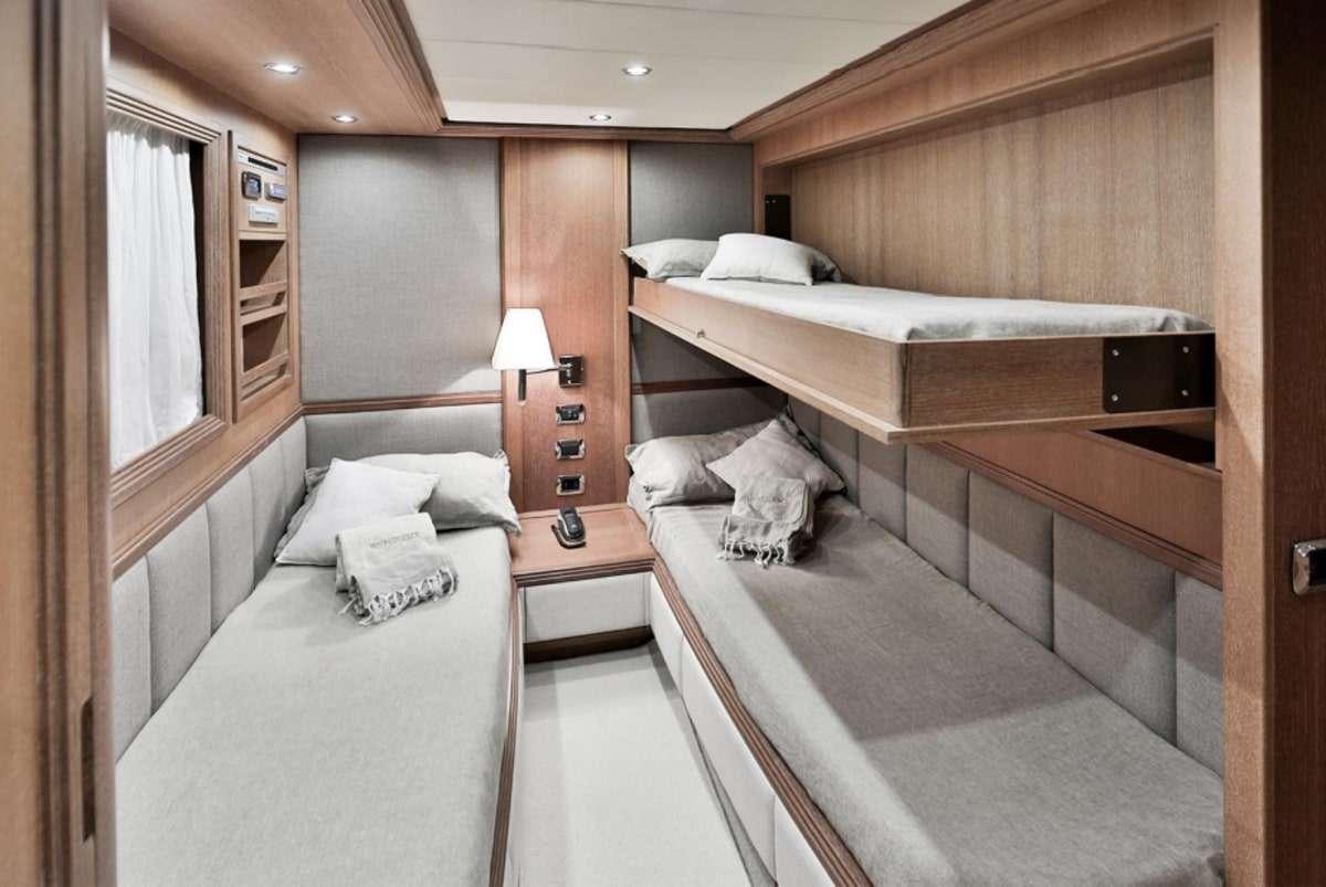 a room with beds and a table aboard RESILIENCE Yacht for Charter