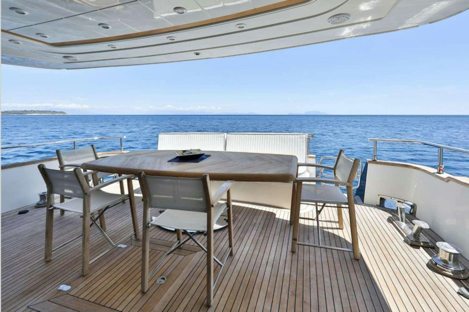 a table and chairs on a deck overlooking the ocean aboard RESILIENCE Yacht for Charter