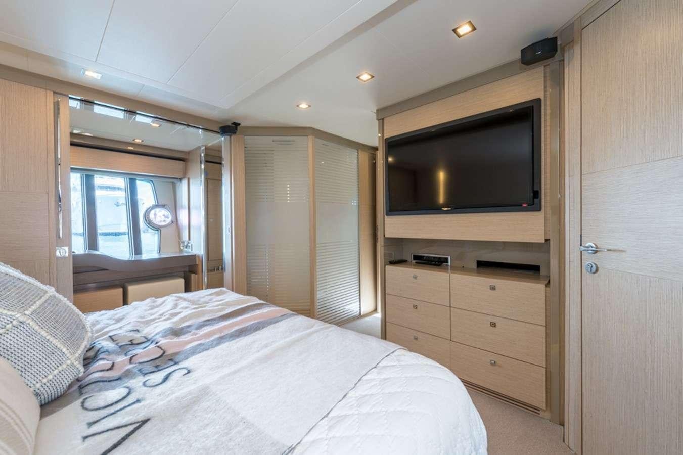 a bedroom with a bed and a television aboard g5 Yacht for Charter