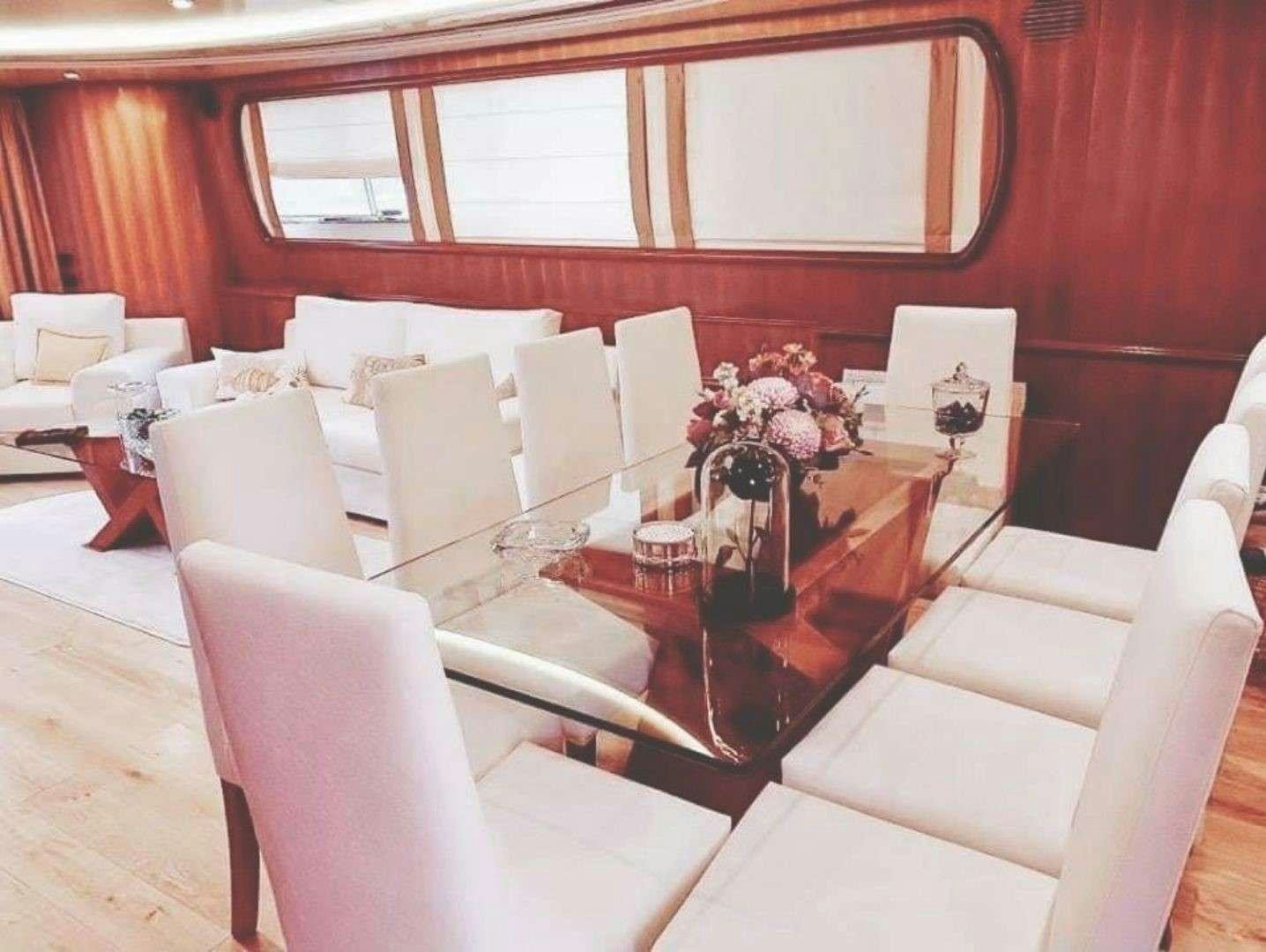 a room with a table chairs and a couch aboard ILLYA F Yacht for Charter